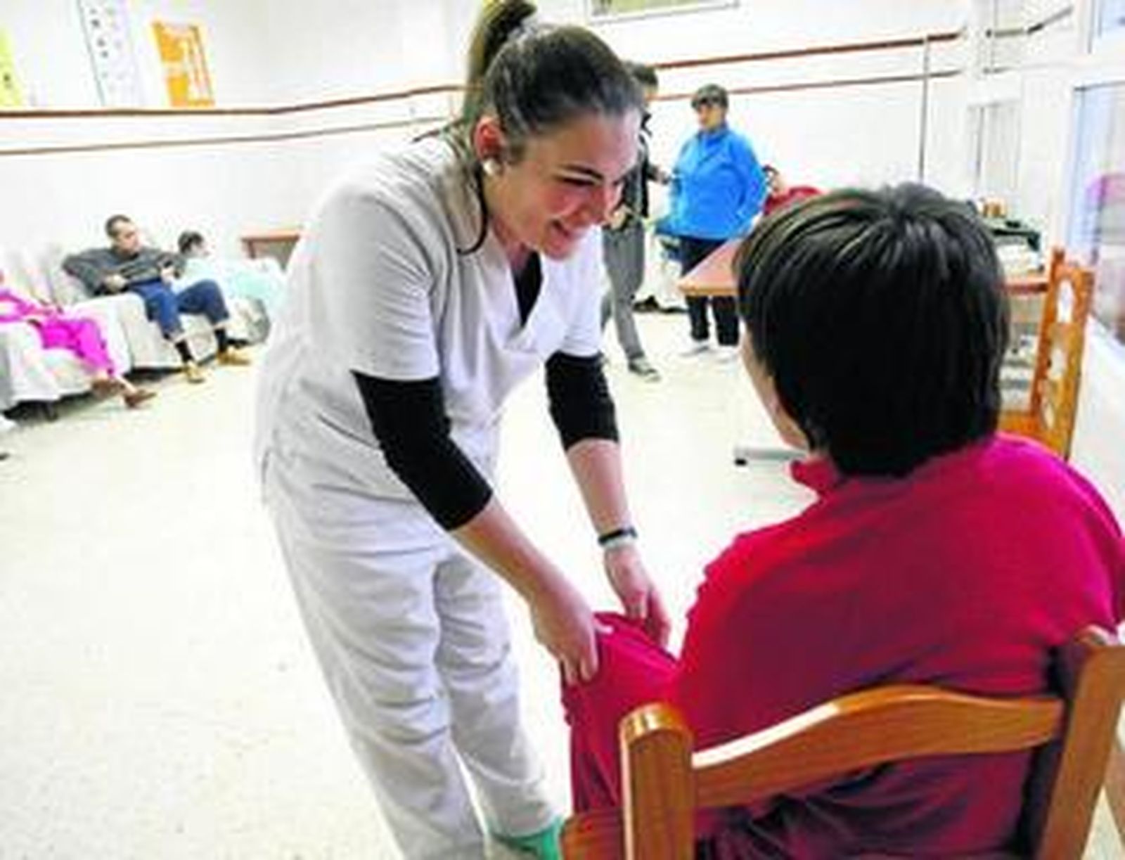 Una trabajadora de Aspromanis atiende a una usuaria de la residencia.