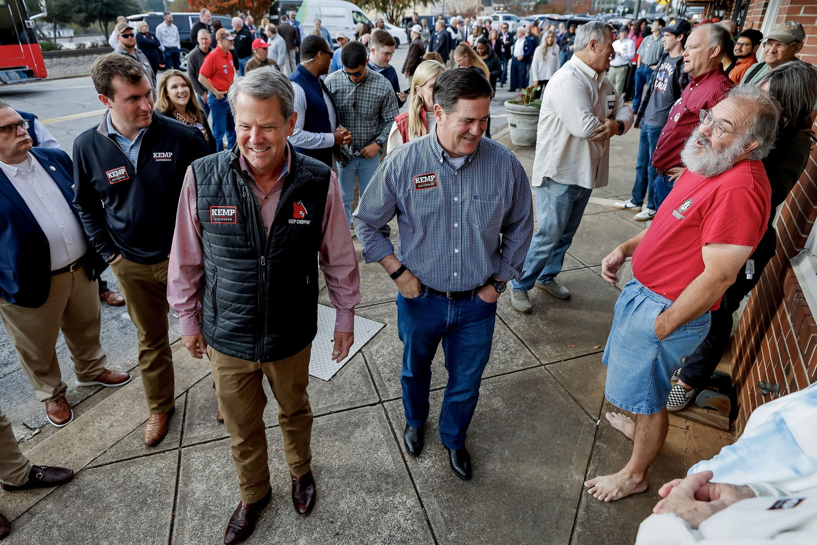 Los gobernadores republicanos de Georgia, Brian Kemp (izq.),  y Arizona, Doug Ducey, saludan durante un acto de campaña en Bremen, Georgia .