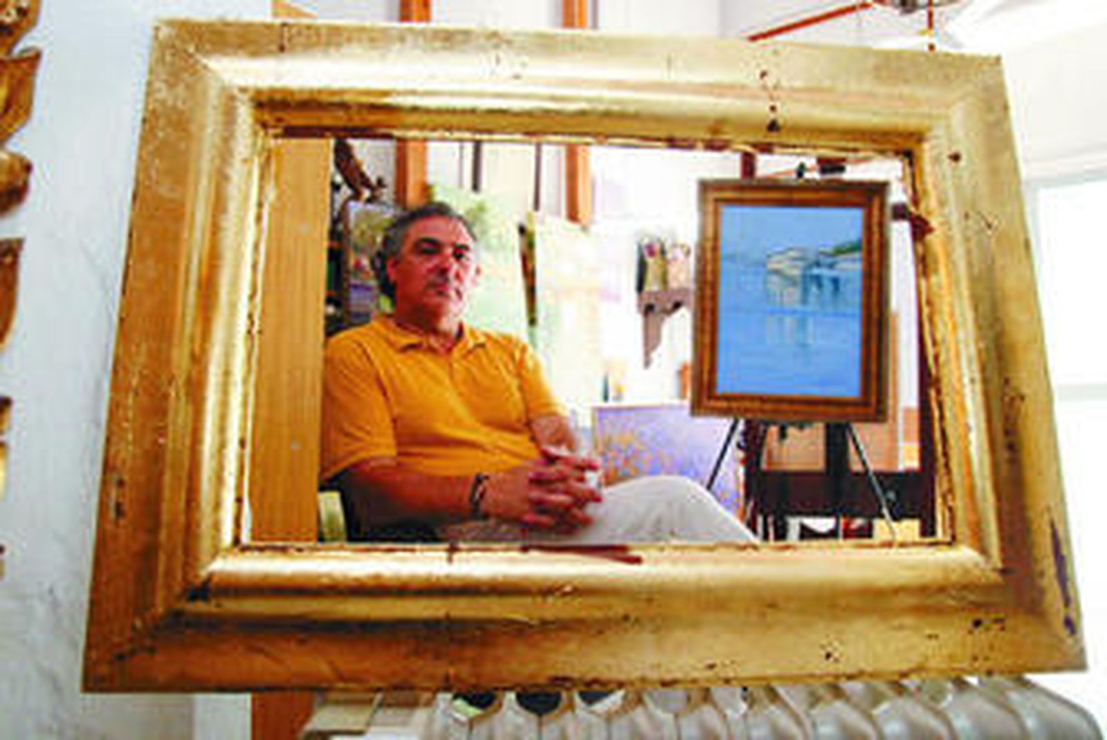 El pintor Ángel Lara, fotografiado en su estudio días atrás, con sus cuadros para la exposición.