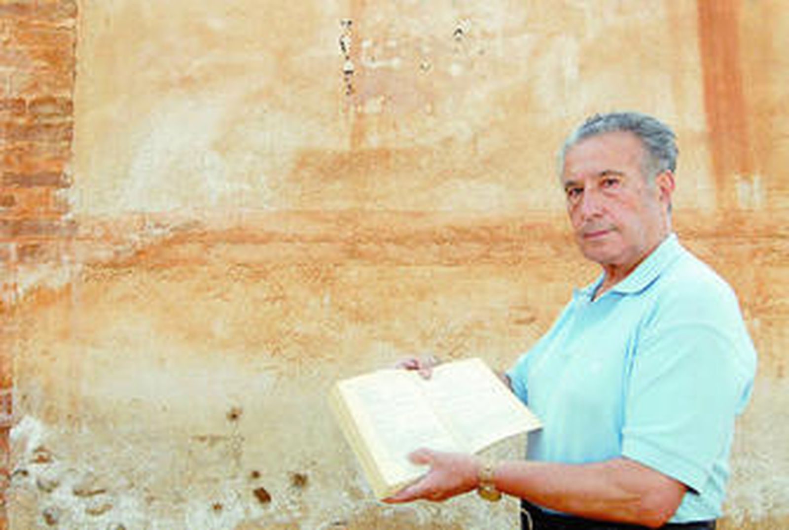 Gabriel Fernández muestra el listado de fusilados que aporta Molina Fajardo en su libro póstumo, junto a la tapia del cementerio.