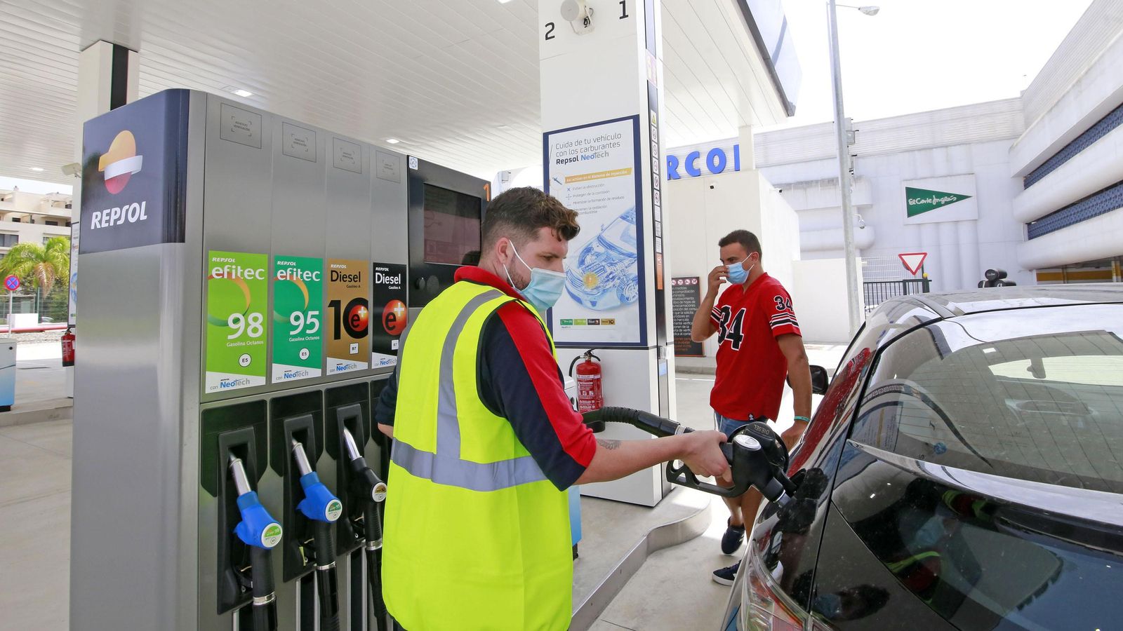 Un empleado de la gasolinera presta servicio a un cliente.