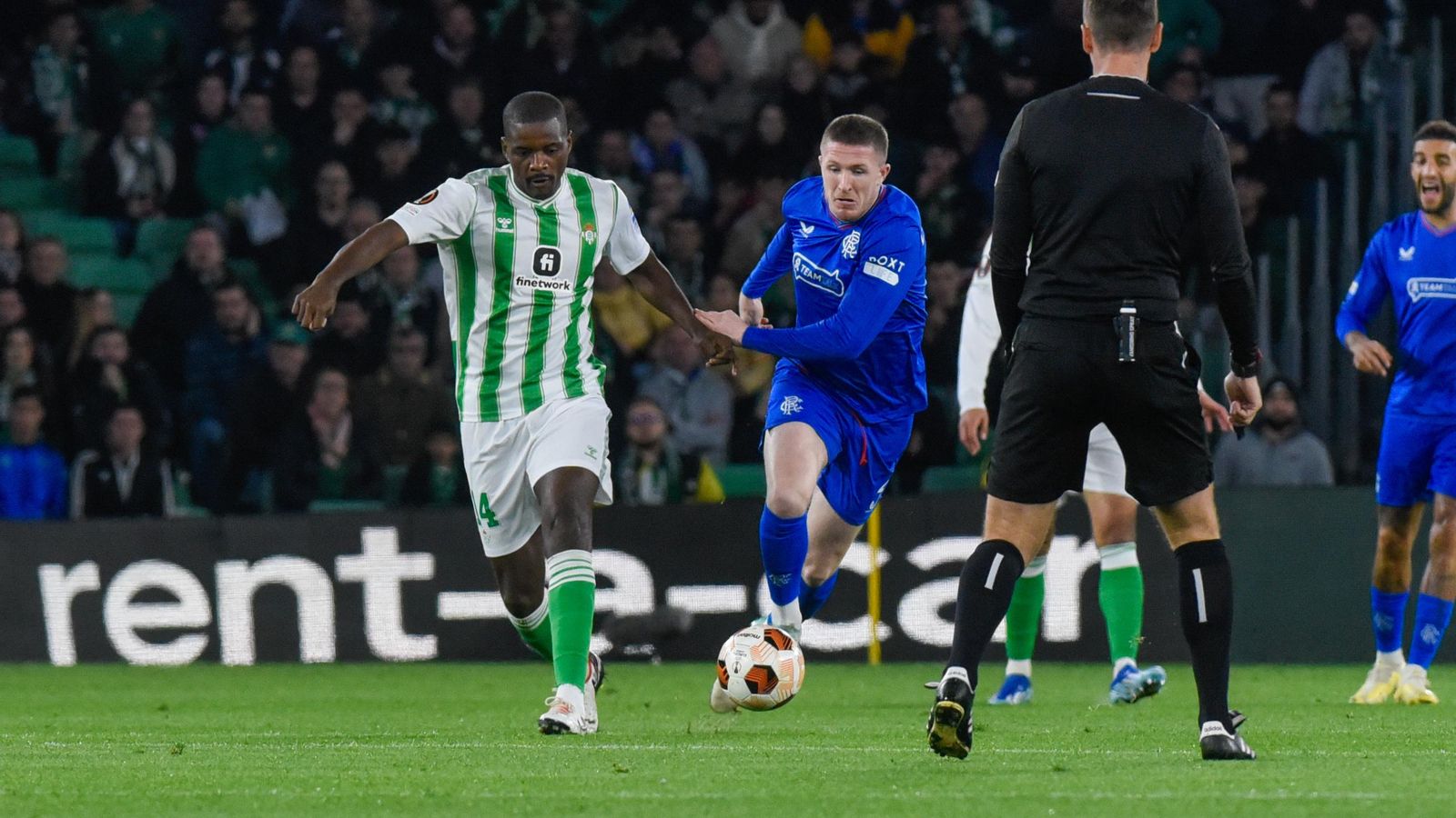 William Carvalho trata de salir con el balón controlado presionado por un rival.