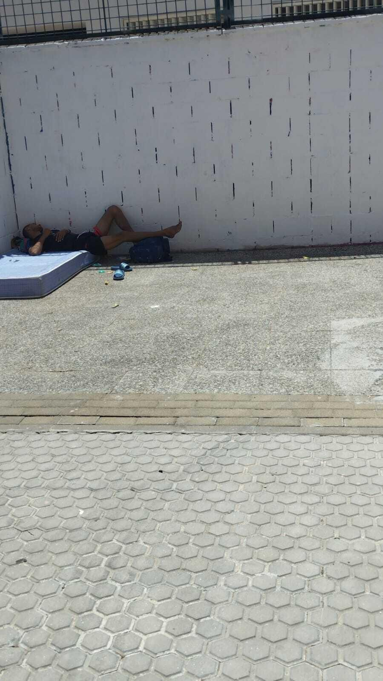 Un hombre pasa la tarde a la sombra en la calle León X.