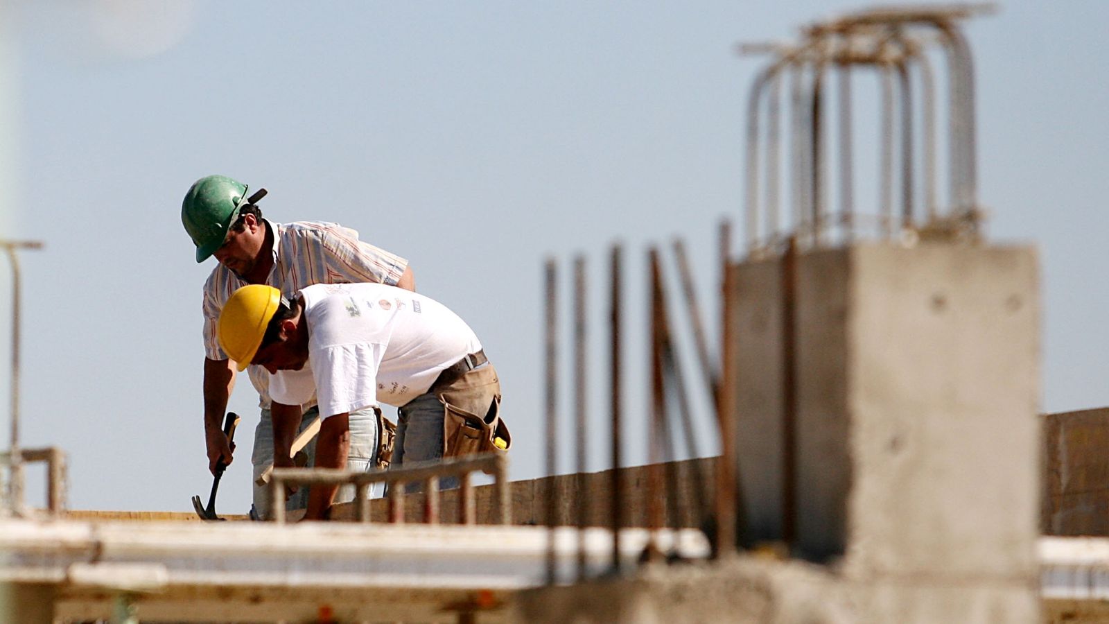 Dos obreros trabajan en una construcción.