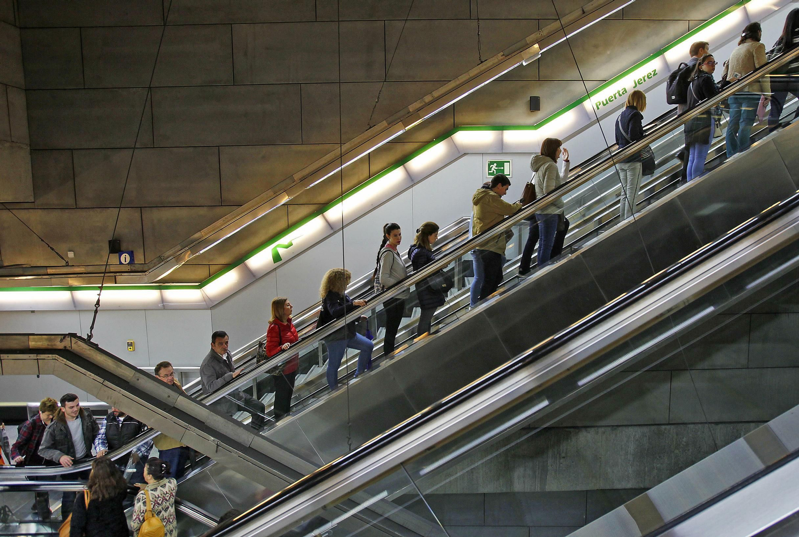 Viajeros suben la escalera mecánica de la estación Puerta de Jerez.