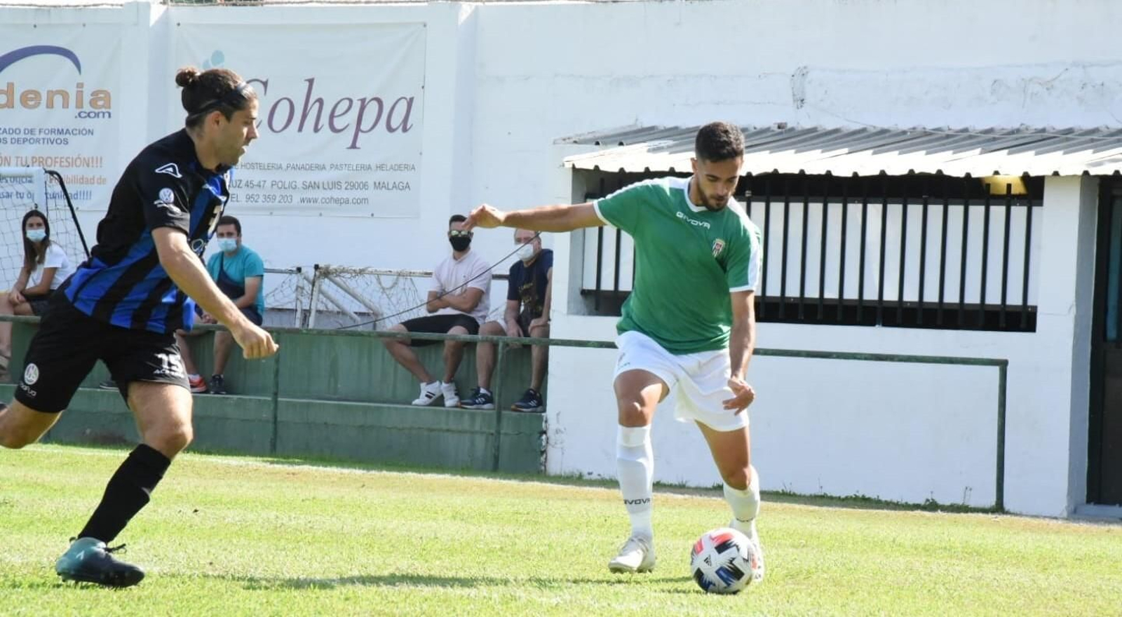 Iván Navarro trata de sacar un centro ante un defensor del Juventud Torremolinos.
