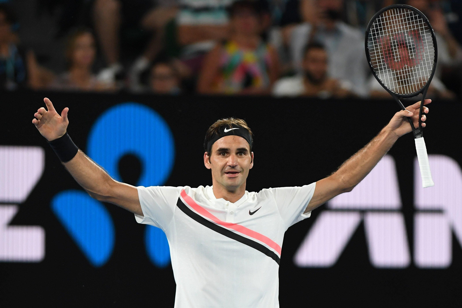 Federer alza los brazos tras ganar un partido.