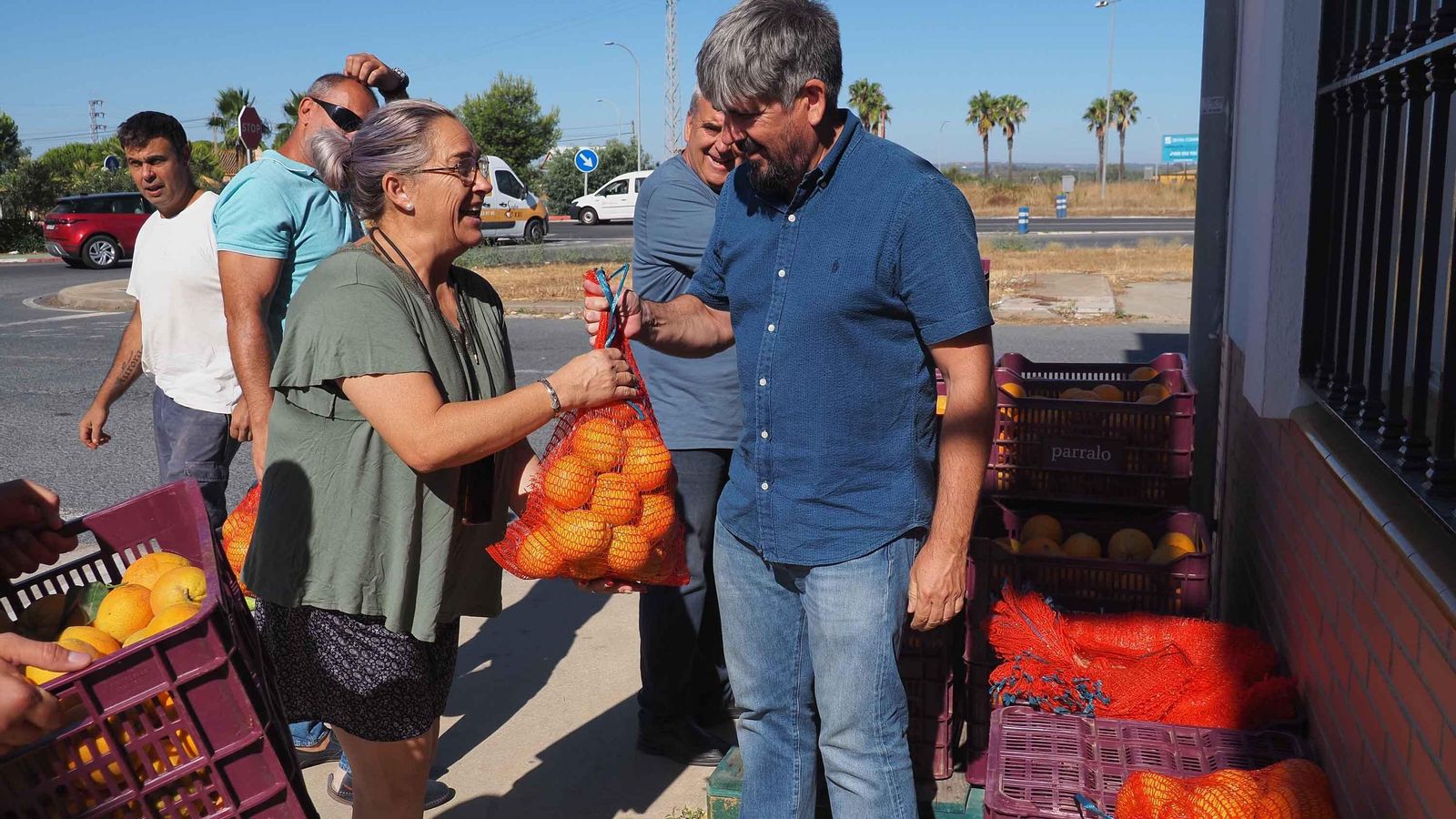 Una mujer recoge un saco de naranjas