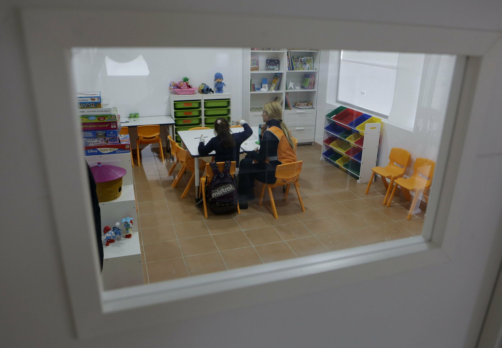 Una educadora junto a una menor en una de las salas de estudio del centro de día para menores de Amate.