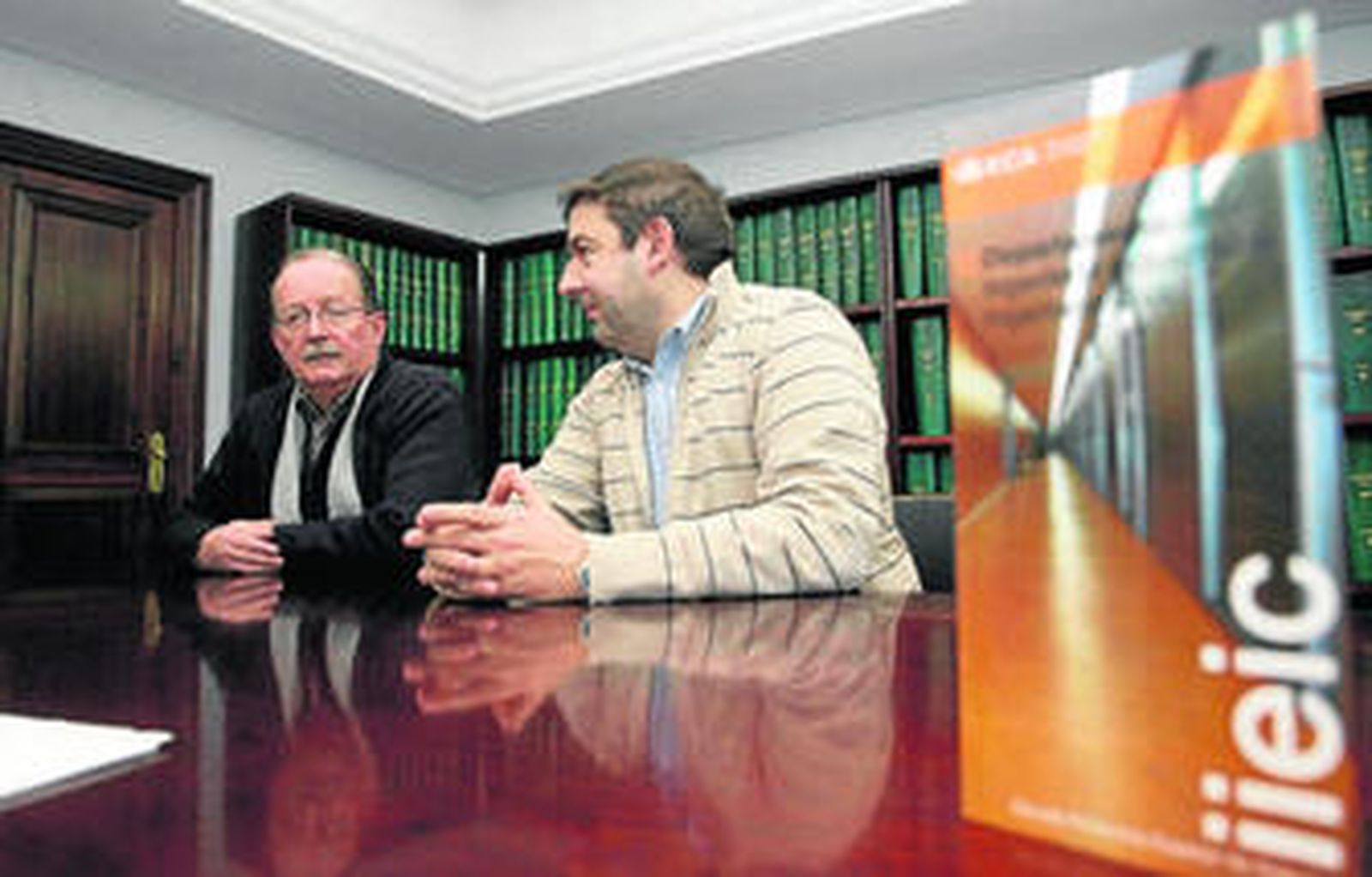 Miguel Ángel Parrón y Raúl Martín, y a la derecha el tríptico del departamento que dirigen.