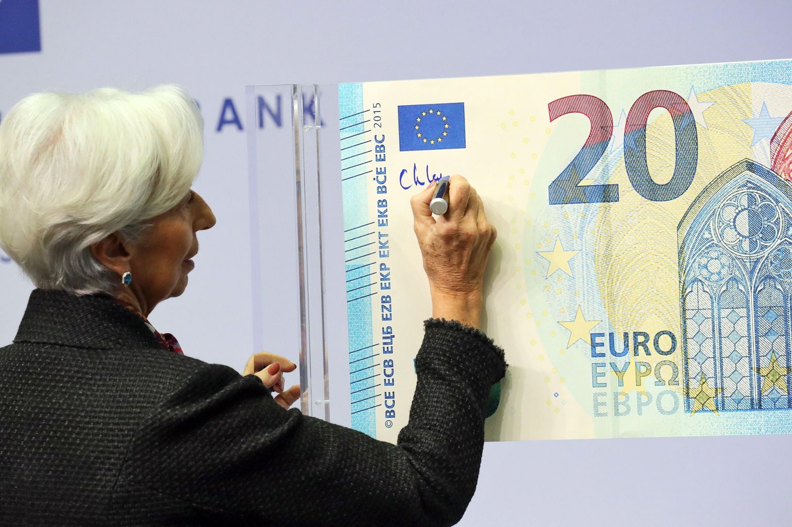 Christine Lagarde, presidenta del BCE, pone su firma en un billete de 20 euros
