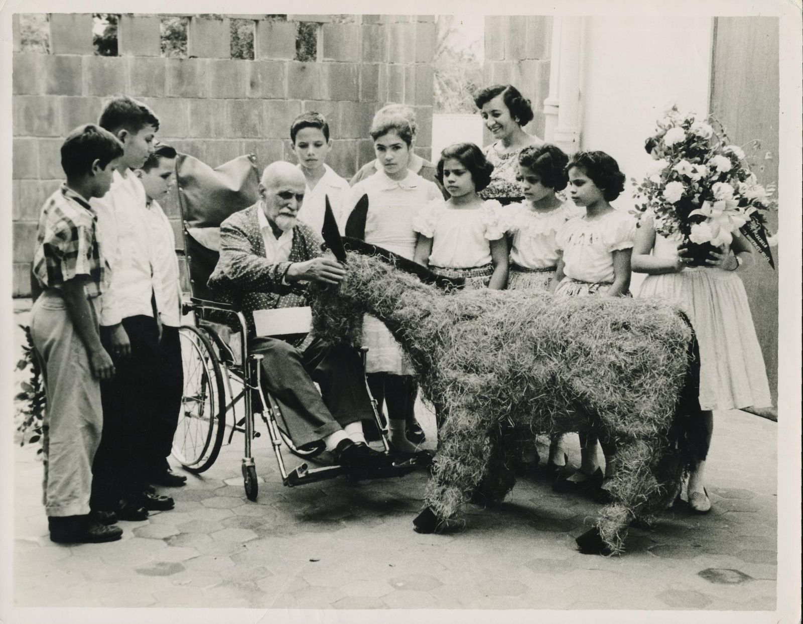 Juan Ramón Jiménez recibe de un grupo de escolares en Puerto Rico una reproducción de Platero en paja y tela. Es la última fotografía del poeta con vida.