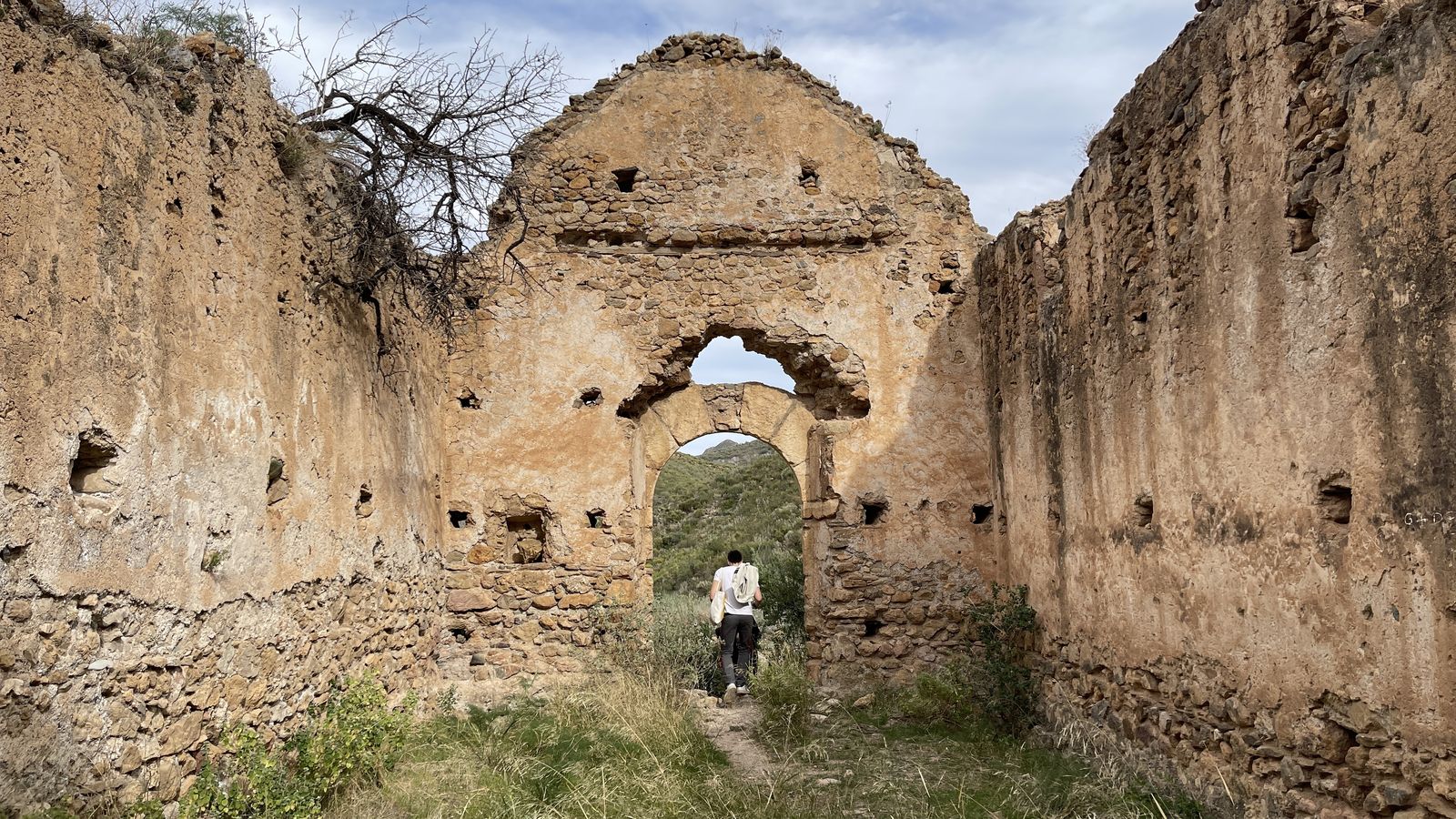 Interior de la iglesia en mayo de 2023, lleno de maleza.