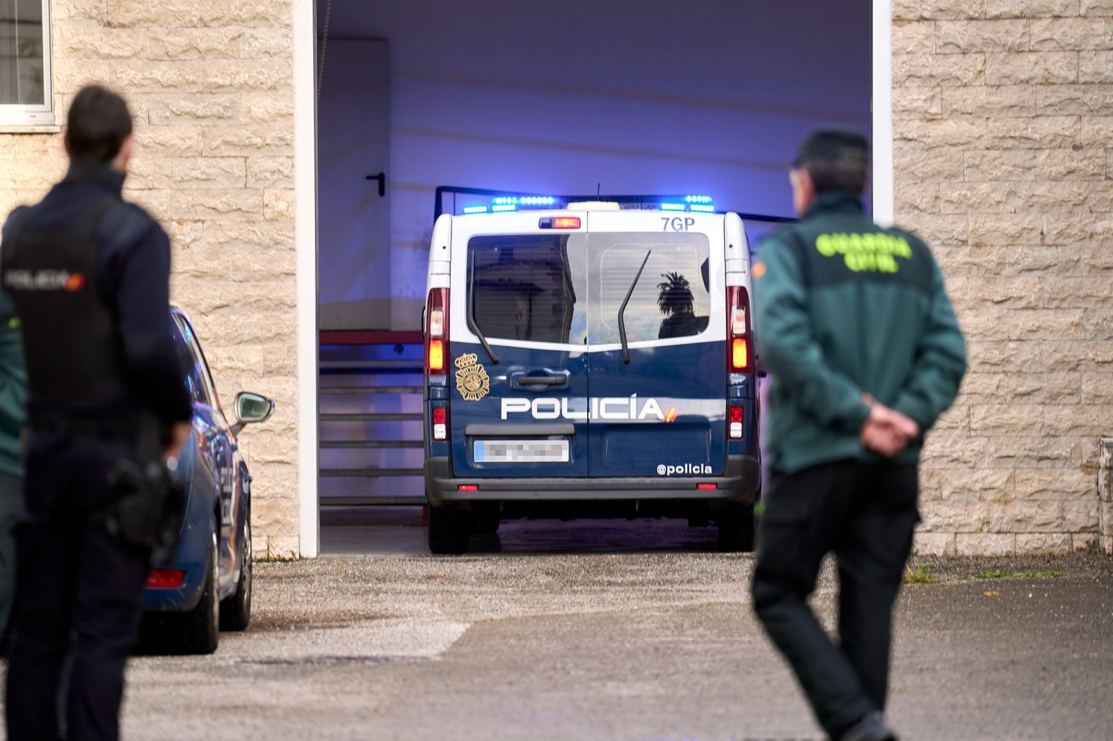 Imagen de archivo de dos agentes del orden junto a un furgón policial.
