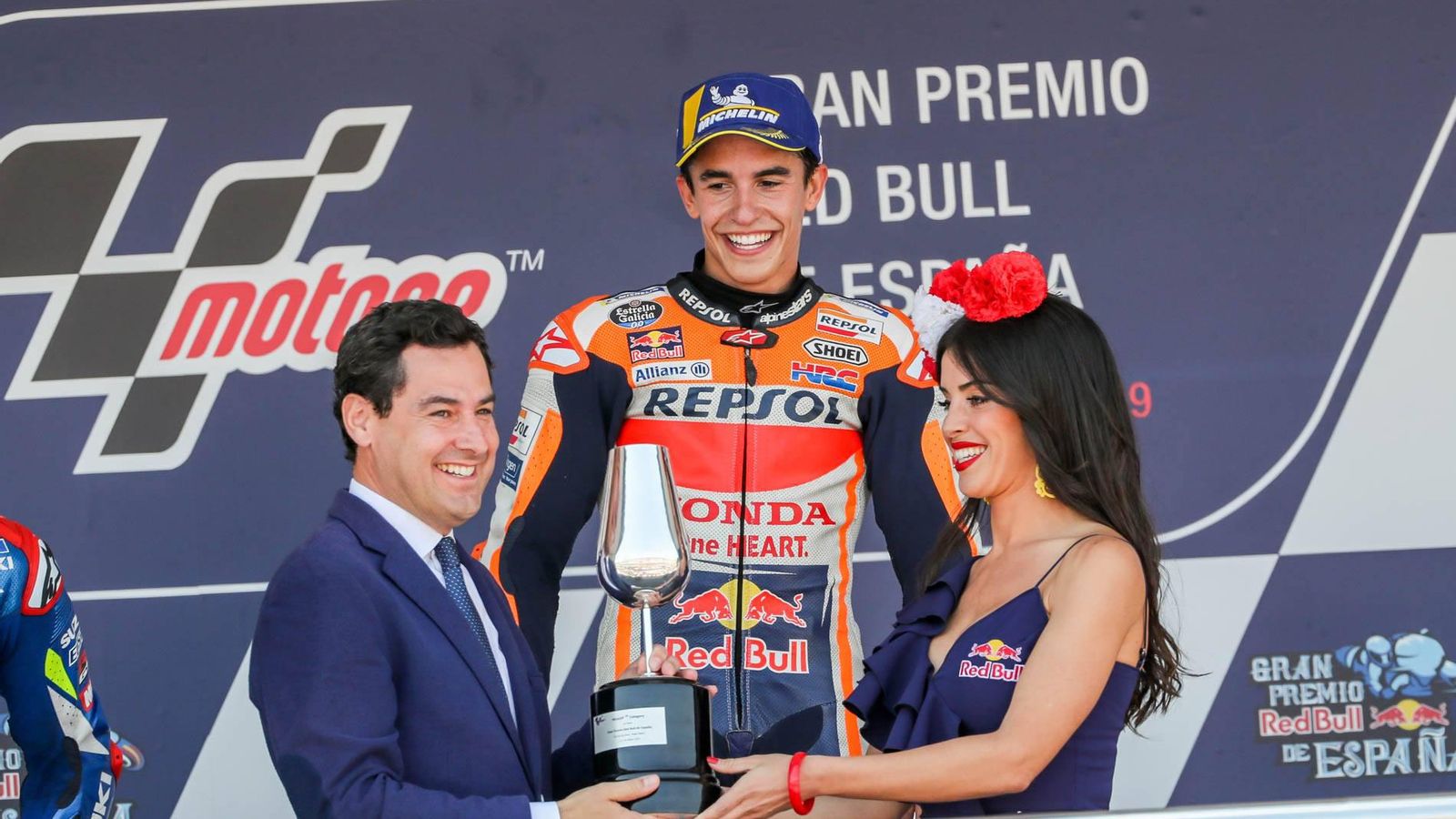 El presidente de la Junta de Andalucía entrega el catavino de ganador a Marc Márquez en el GP de 2019.