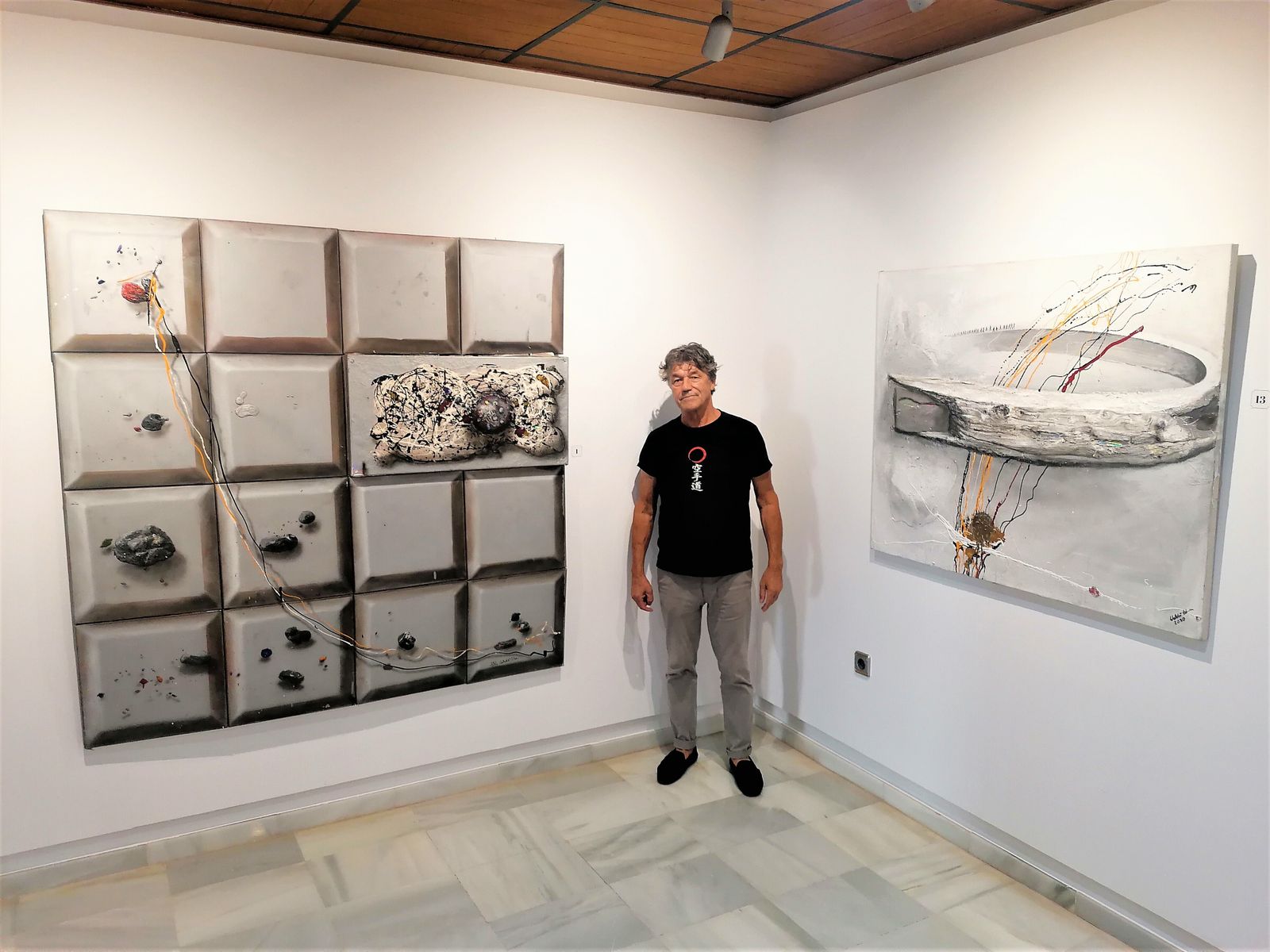 Waldi Wrobel junto a dos de las obras que expone en el Castillo de Santa Ana en Roquetas de Mar.