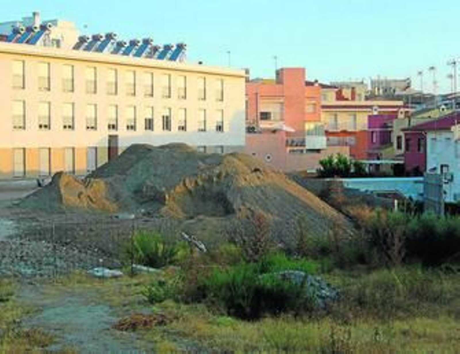 Imagen de las montañas de arena apiladas de las VPO junto a las casas de los vecinos afectados.