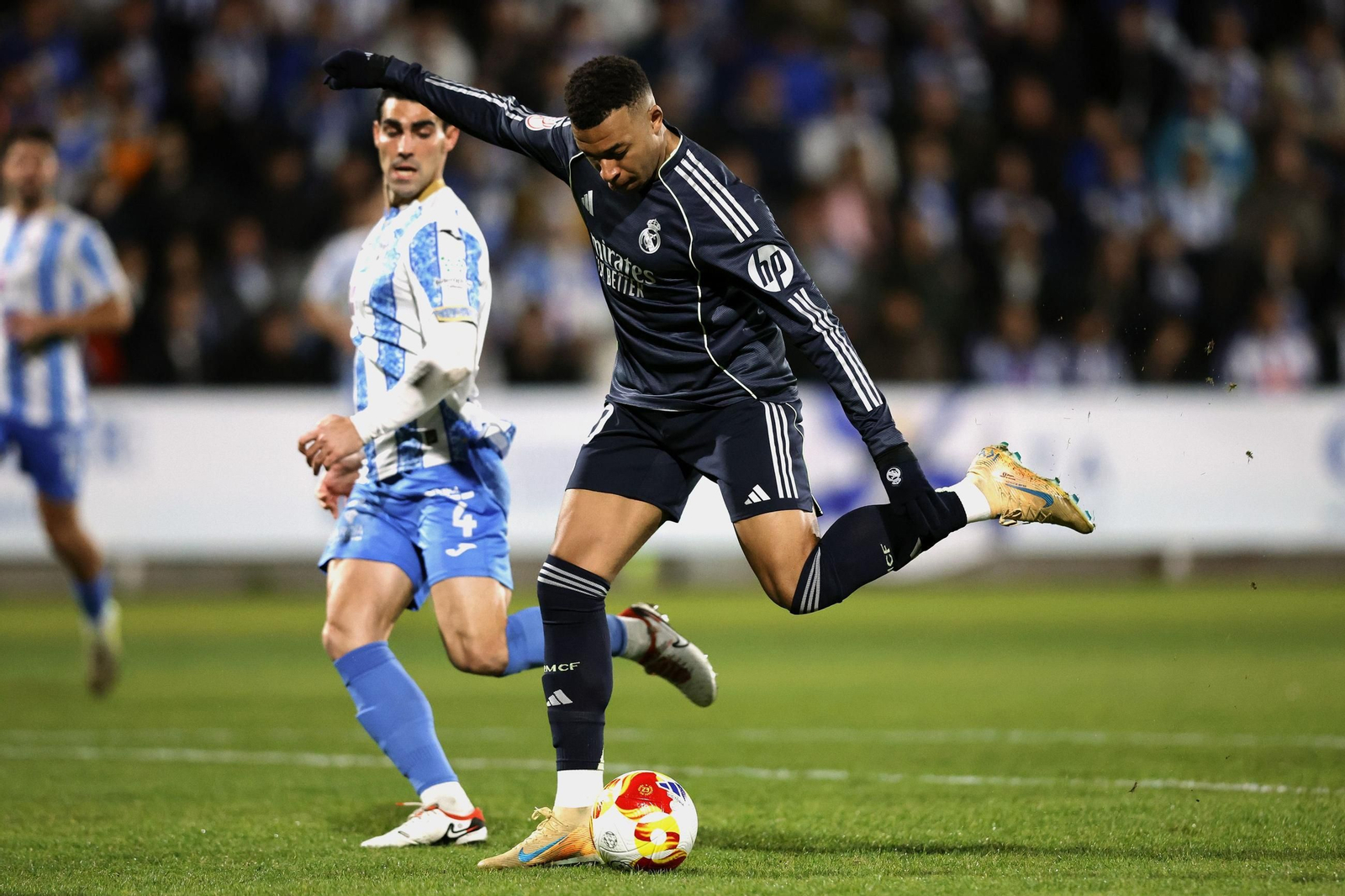 Mbappé golpea la pelota en presencia de Álvaro López.