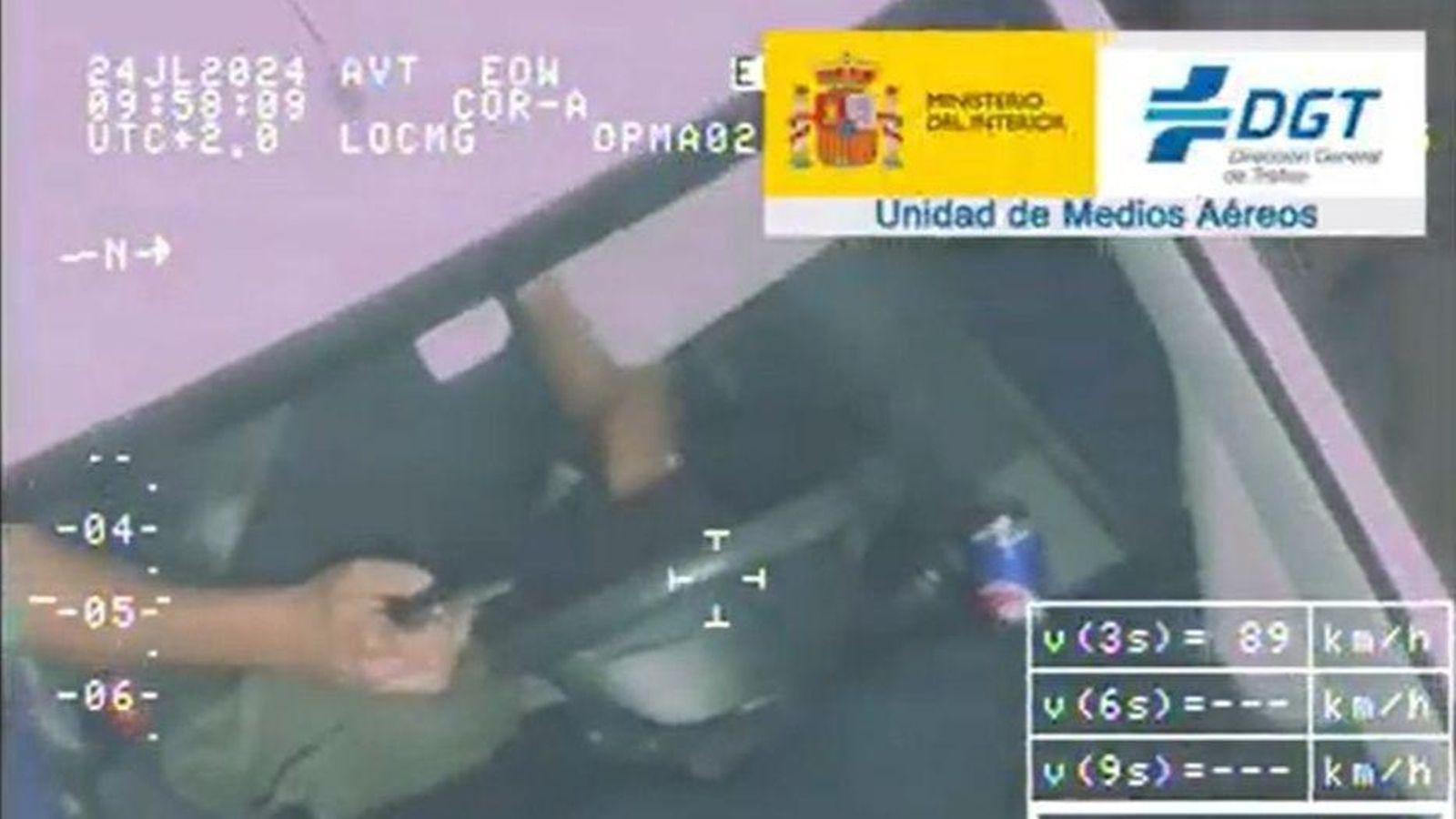 Una persona cicula por una carretera de la provincia de Granada usando el móvil