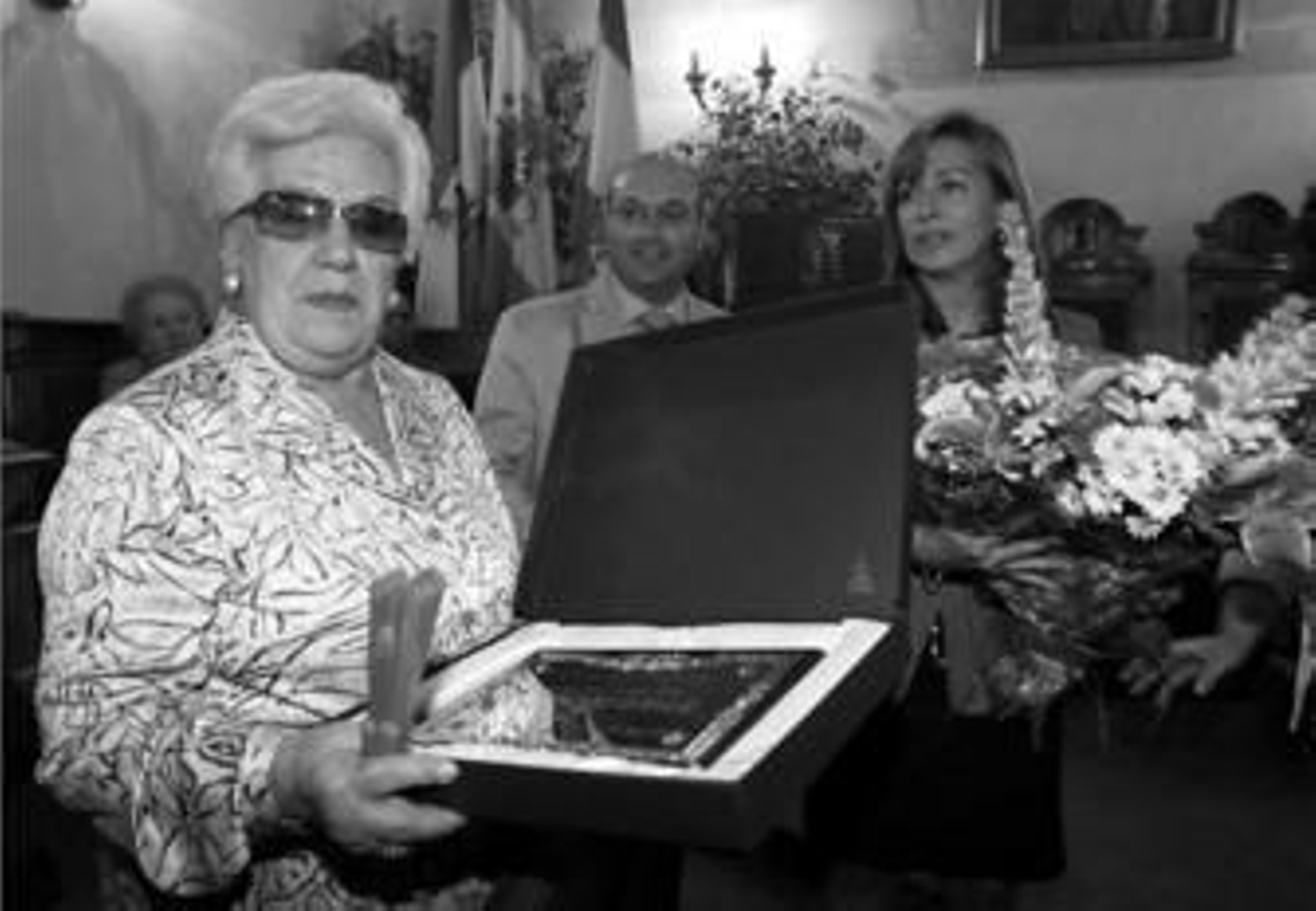 Una de las hijas de Dolores Flores recogió la placa en nombre de su madre, que no pudo asistir al acto.