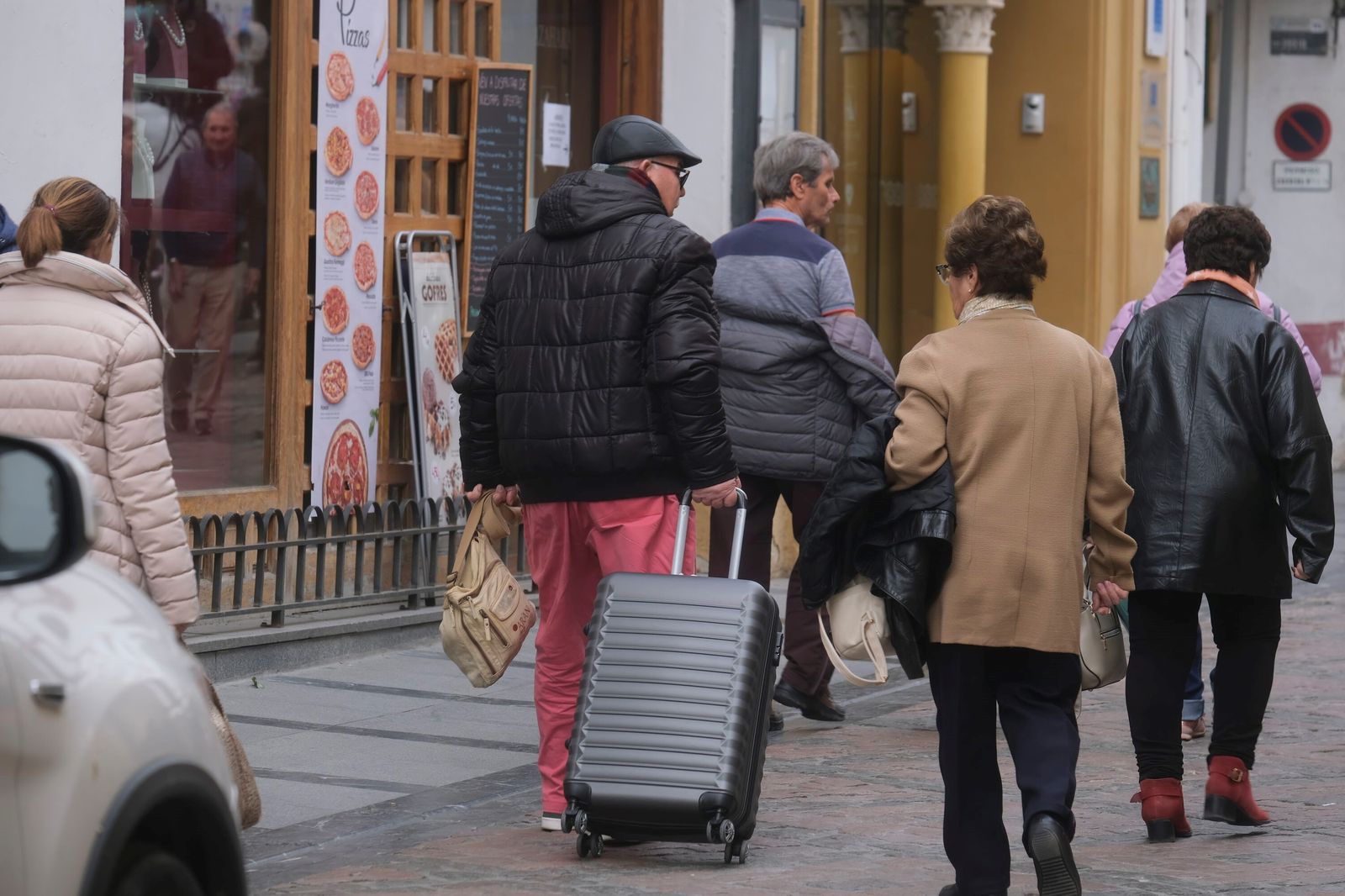 Varias personas con maletas recorren el centro de Córdoba.