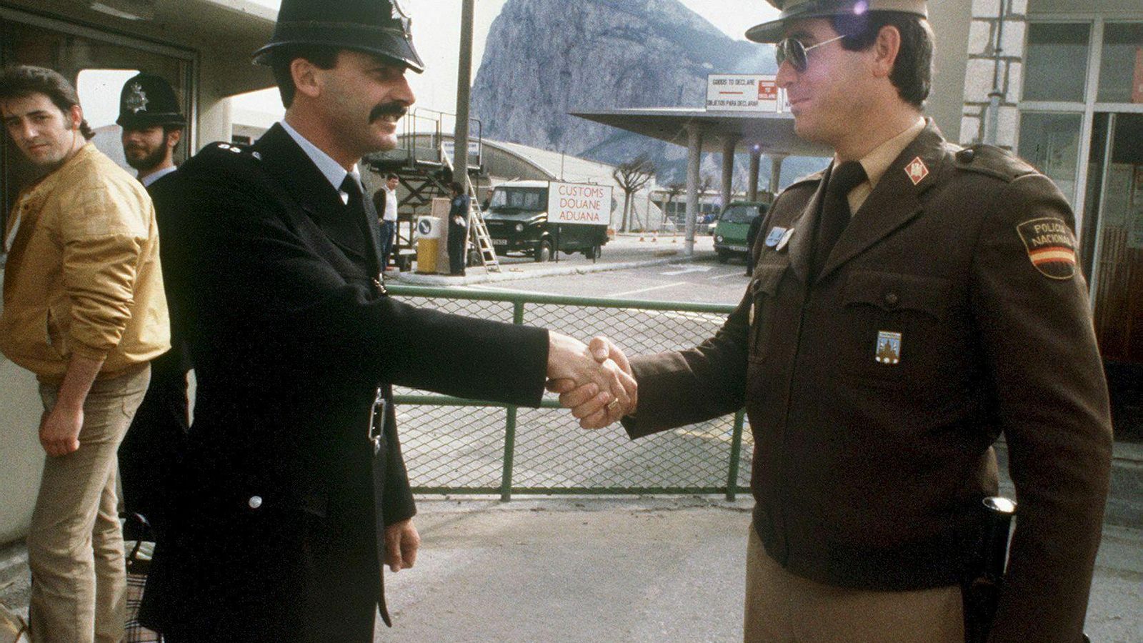 Un Policía Nacional saluda a un Bobby inglés en el límite de la Verja, horas antes de su apertura al tráfico en 1985.