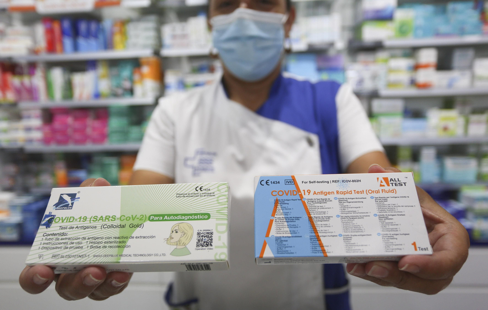 Una farmacéutica muestra dos test de antígenos.
