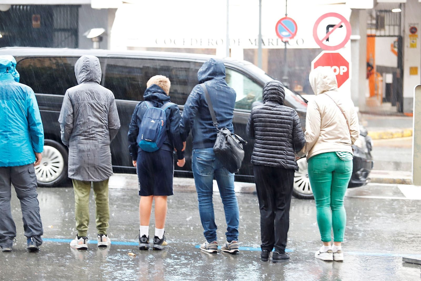 Ciudadanos con chubasqueros bajo la lluvia.