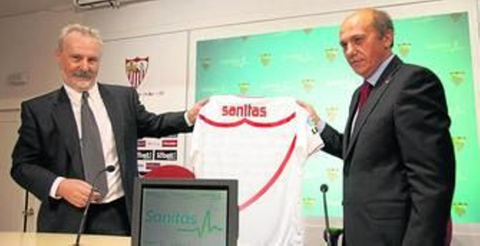 José Manuel Sánchez, director general de marketing de Sanitas, y José María del Nido posan con la camiseta del Sevilla.