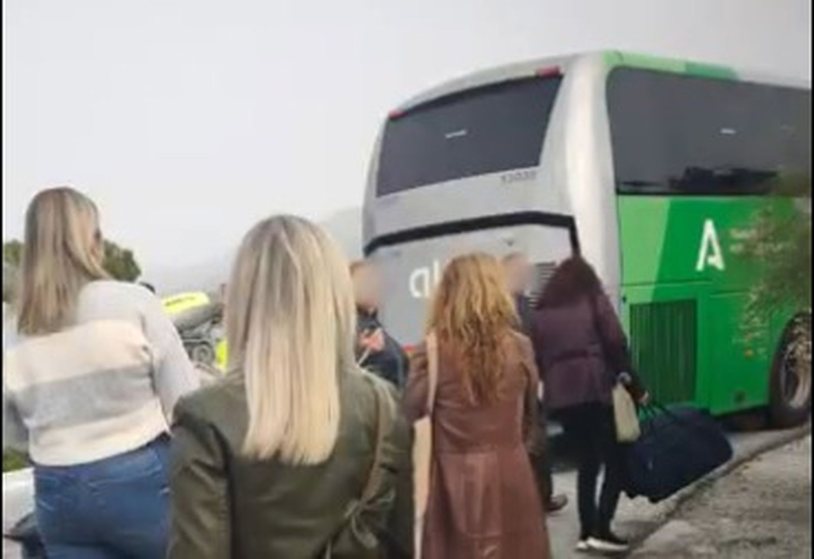 Pasajeros parados en la carretera tras la avería de un autobús
