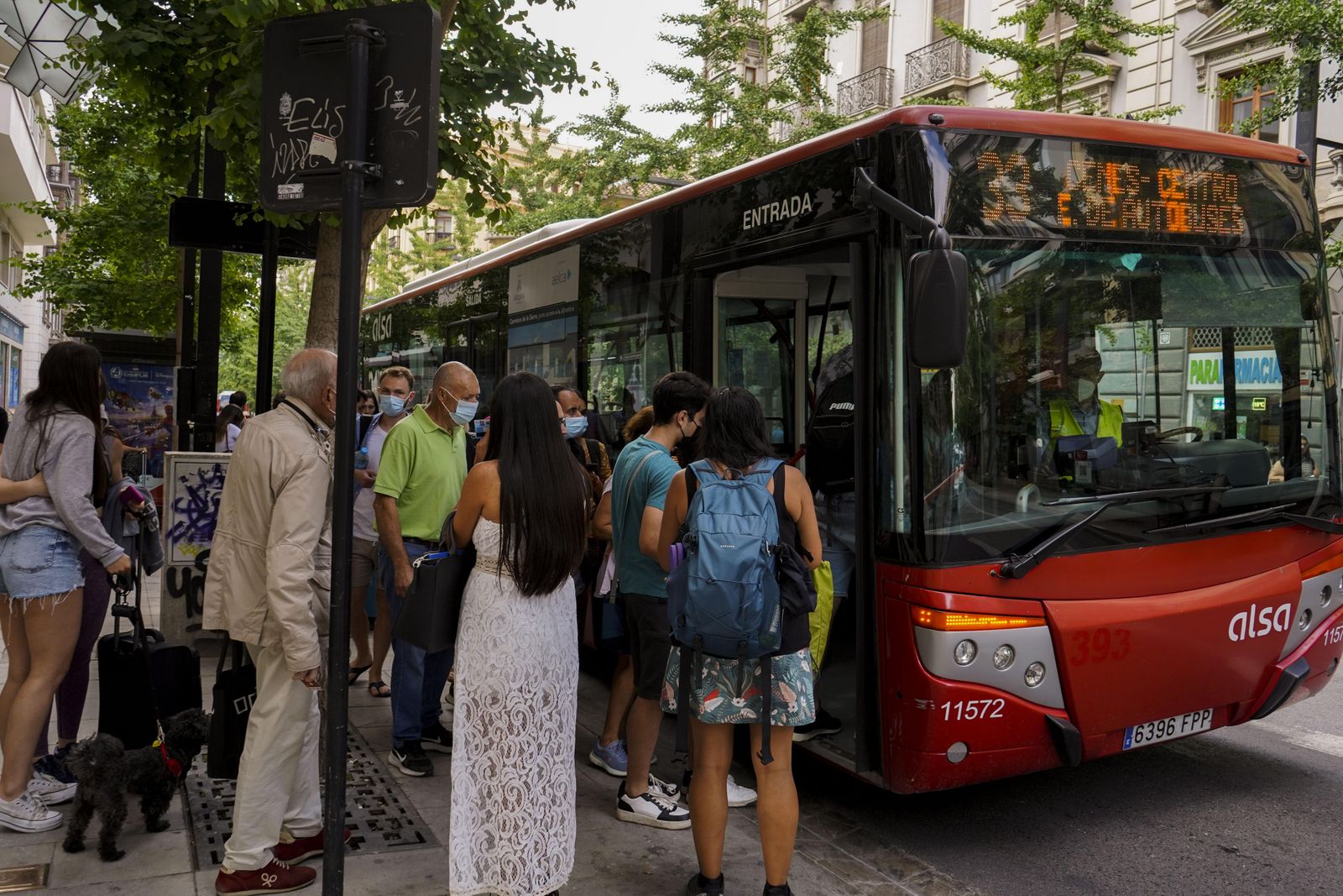 Varias personas hacen cola para coger un autobús.