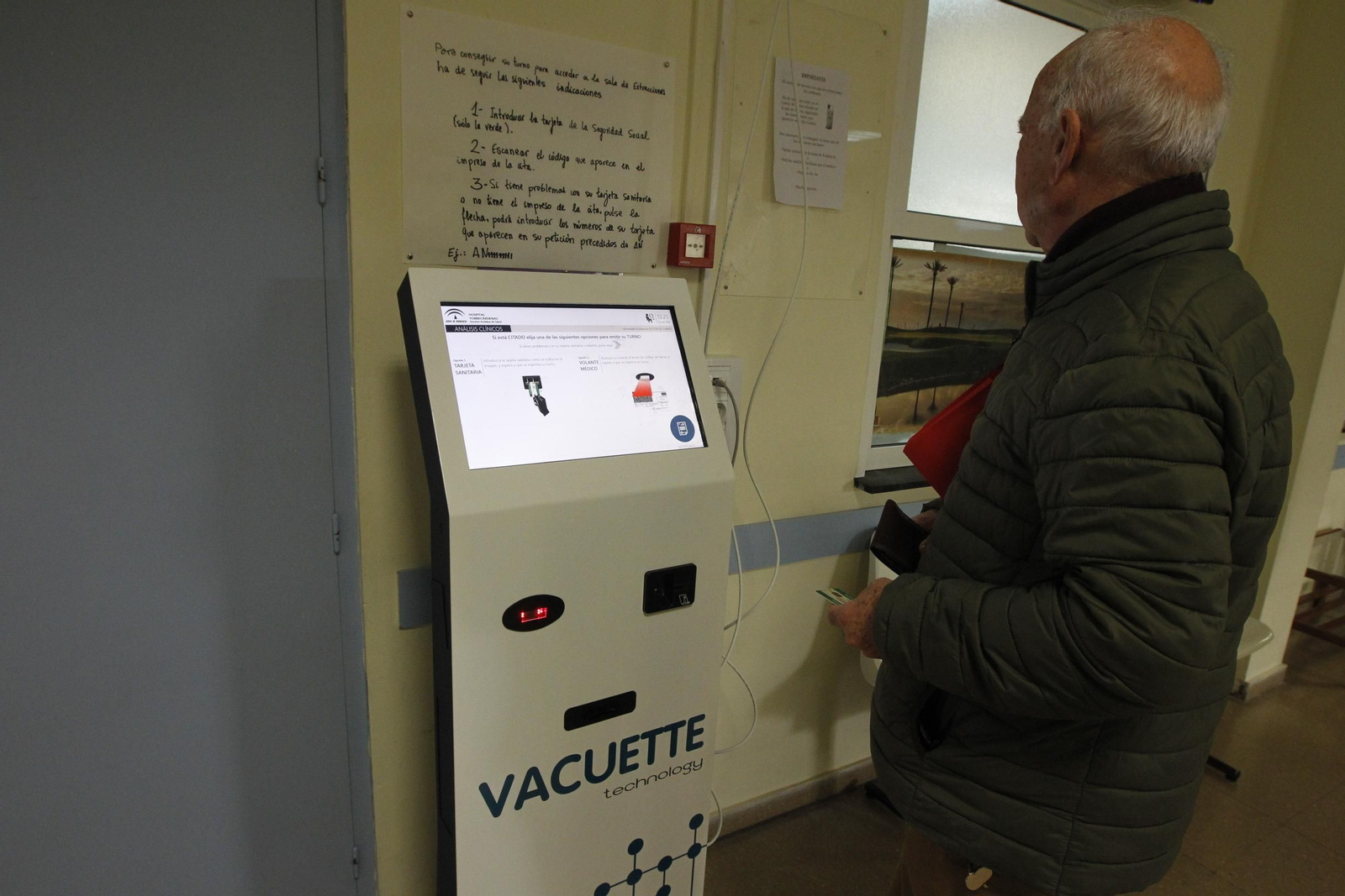 Un usuario espera a que la máquina le de el tiquet con su turno para extracciones en la Bola Azul.