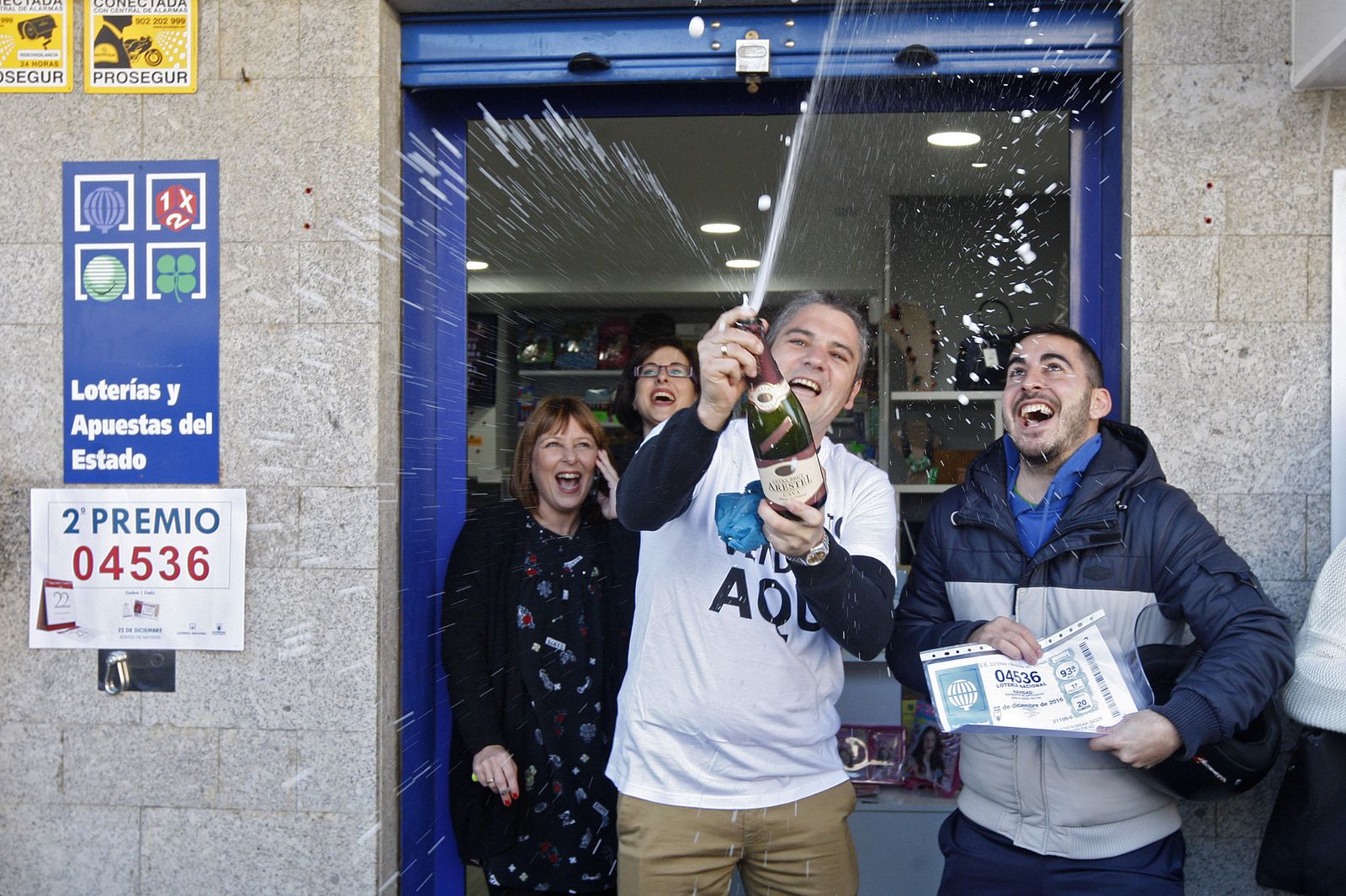 Juan Antonio y su mujer Marián celebran con cava la venta del segundo premio en presencia de Miguel Hidalgo, uno de los premiados.