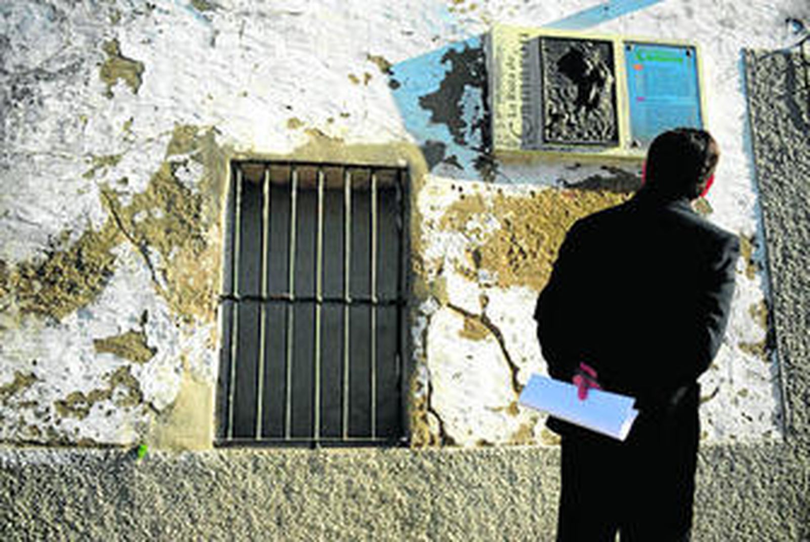 El alcalde, José Loaiza, de espaldas, contempla la fachada y la inscripción que existe en la casa natal de Camarón de La Isla.