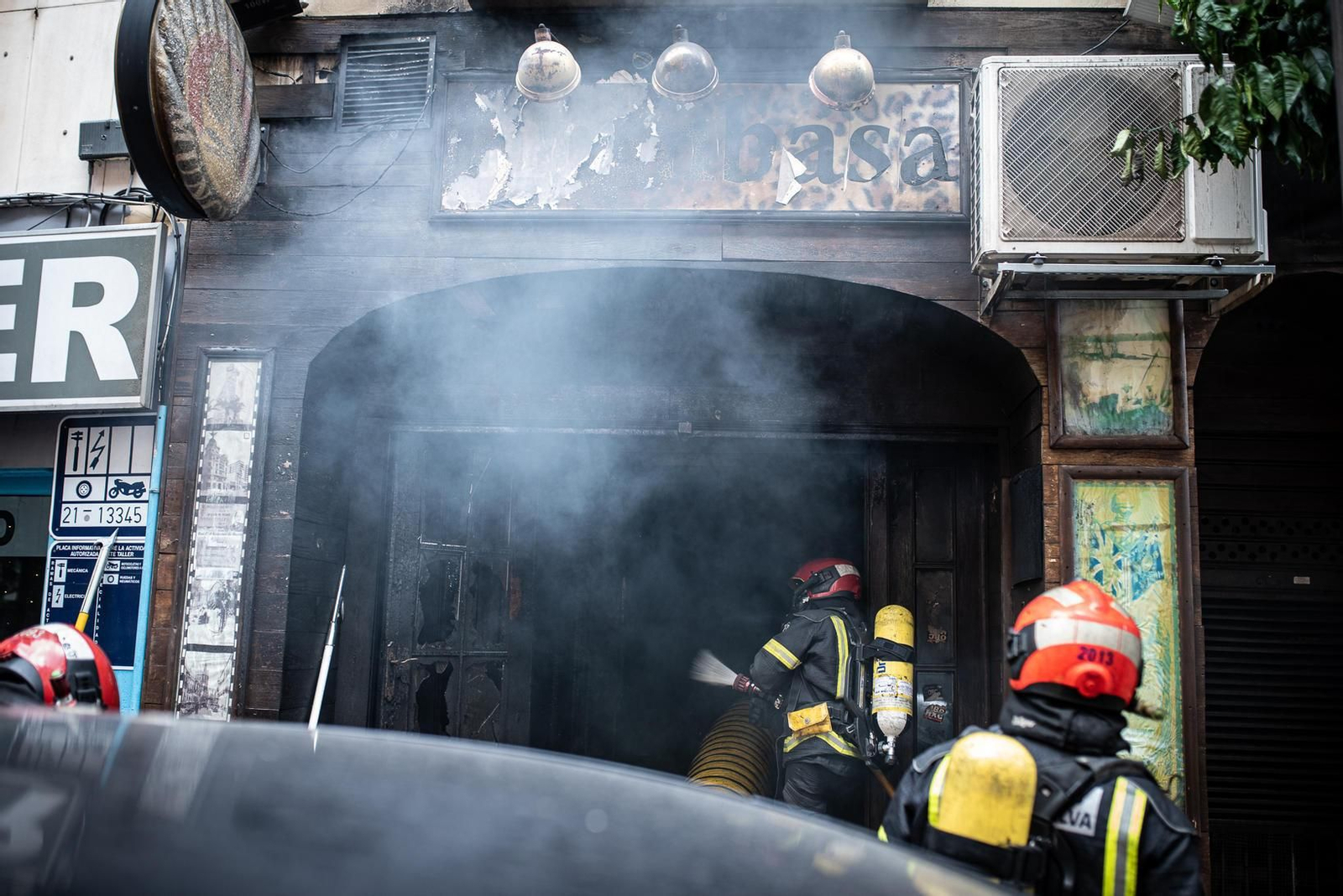 Varios miembros del Cuerpo de Bomberos en pleno operativo para extinguir el incendio en el bar Mombasa de la capital.