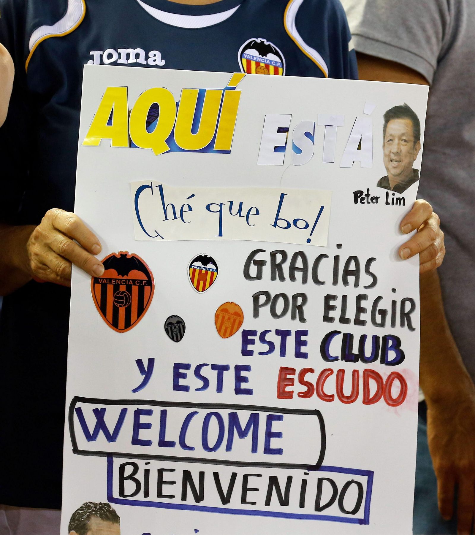 Un aficionado del Valencia muestra una pancarta de bienvenida a Peter Lim en 2014.