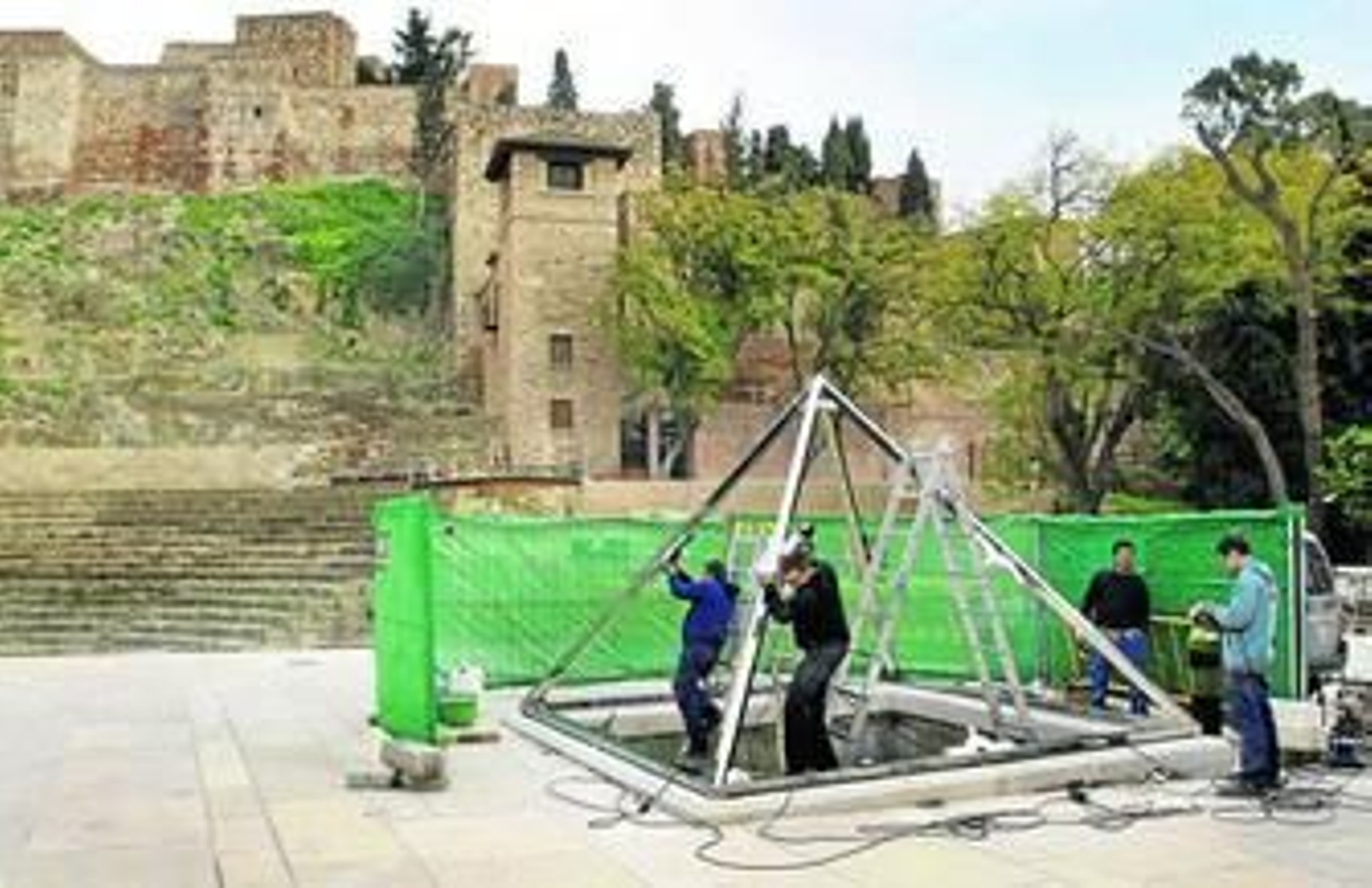 Varios operarios trabajan en la instalación de la pirámide.