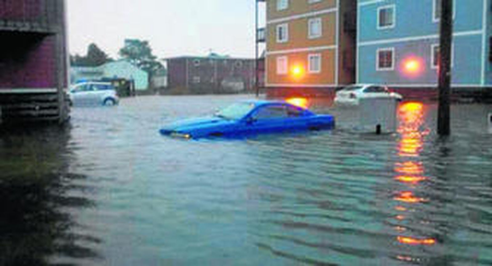 Imagen de una de las calles de Norfolk (Virginia) donde se puede ver un automóvil atrapado entre la ría que provocó Sandy.