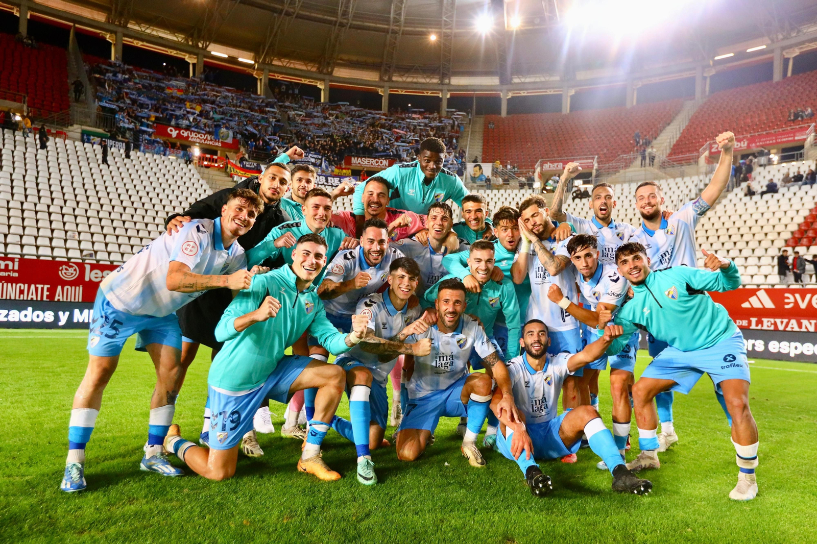 Los jugadores del Málaga CF celebran con la afición al fondo.
