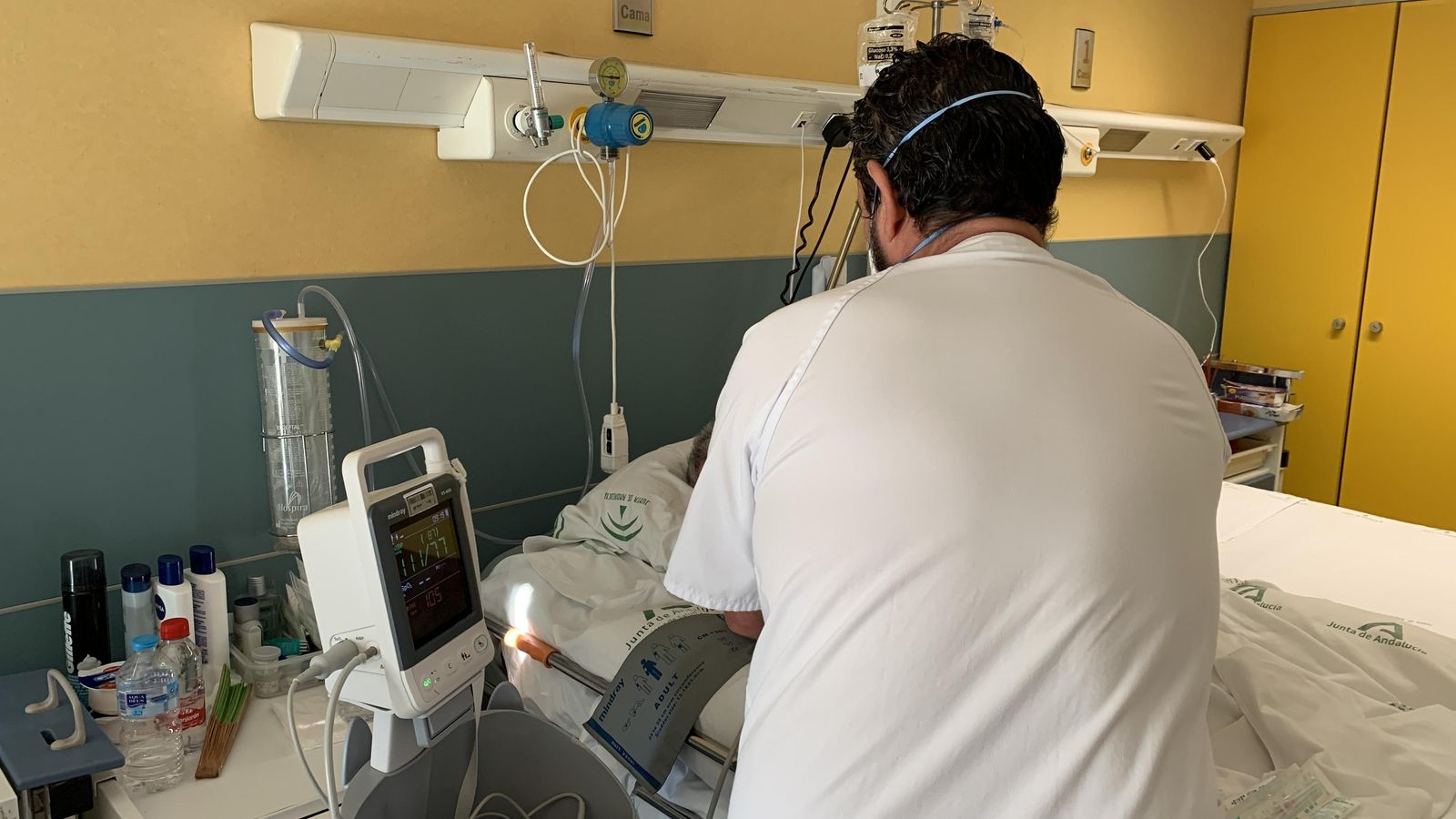 Personal sanitario durante la asistencia a un enfermo en la unidad de hospitalización del centro.