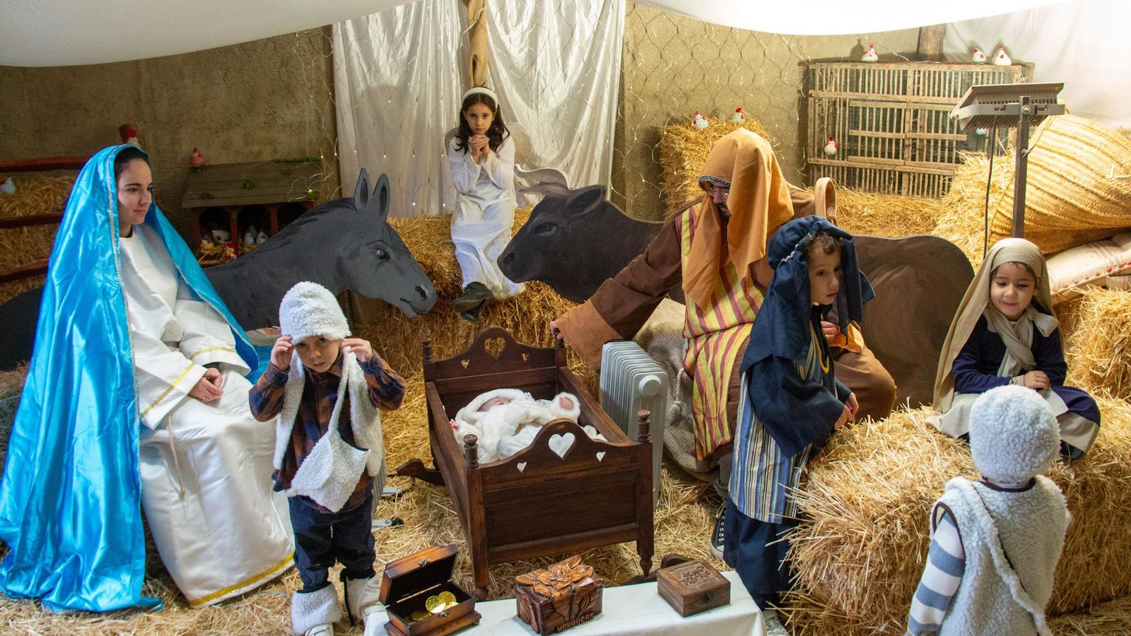 Varios pastorcillos pasan el rato junto al Nacimiento