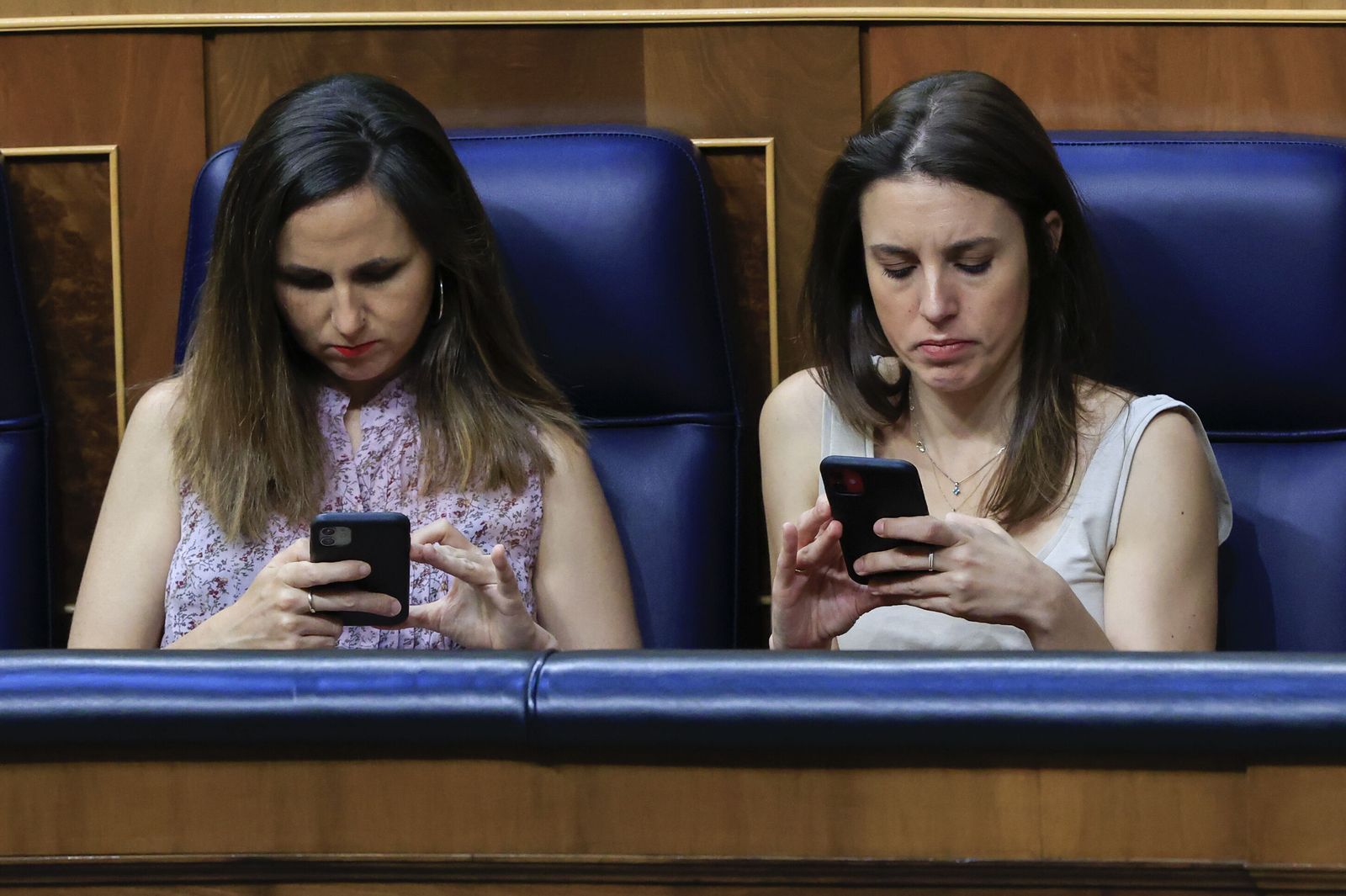 La ministra de Derechos Sociales, Ione Belarra, y la de Igualdad, Irene Montero, consultan sus móviles en el Congreso