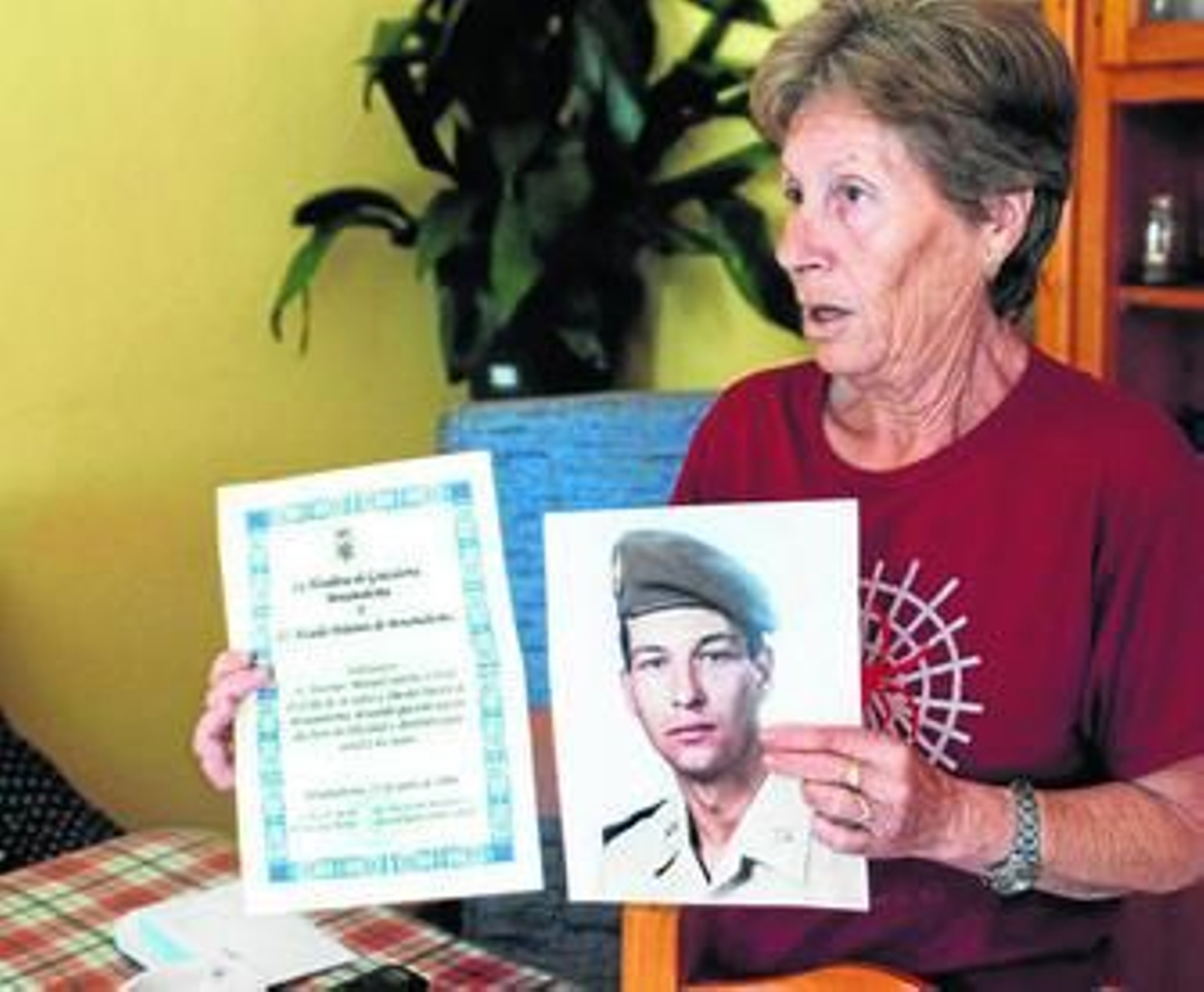 Antonia sostiene una foto de su hijo de militar y una felicitación de cumpleaños del alcalde de Grazalema.