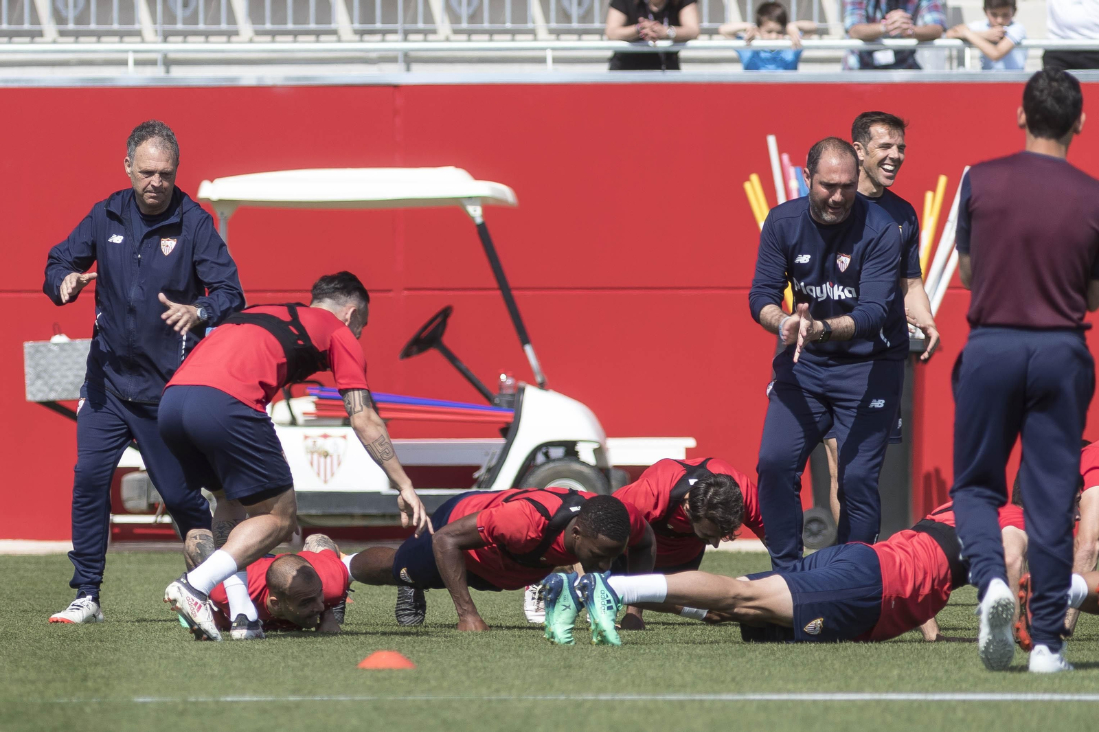Un hiperactivo Juanjo del Ojo, a la derecha, anima a varios jugadores en un ejercicio lúdico con flexiones integradas en la tarea de entrenamiento.