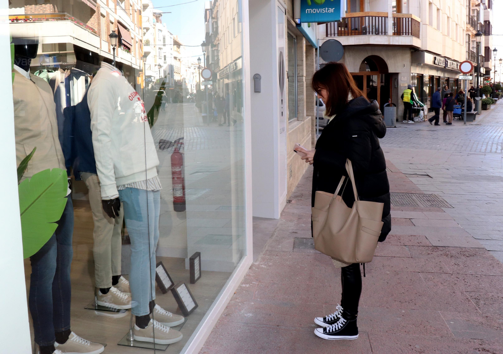 Una persona observa el escaparate de una tienda de ropa.