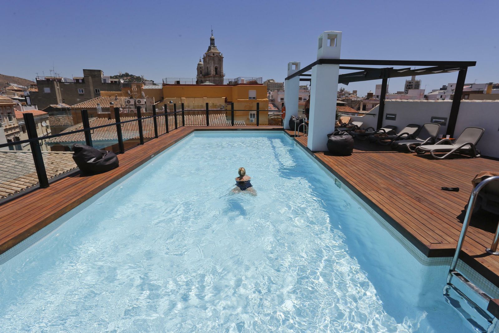 Una persona se baña en la piscina de un hotel en Málaga capital