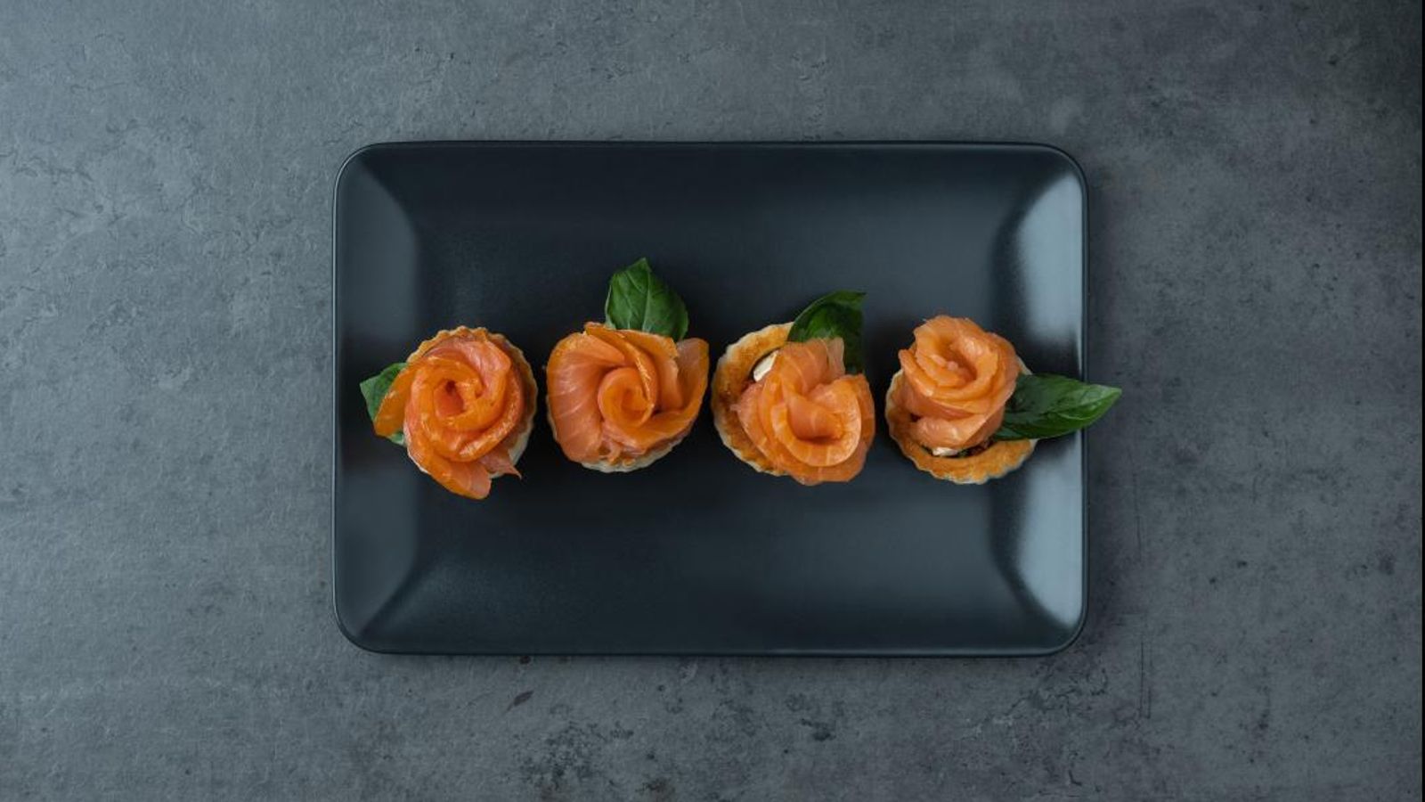 Volovanes de queso feta, tomate seco y albahaca con rosas de salmón ahumado noruego.