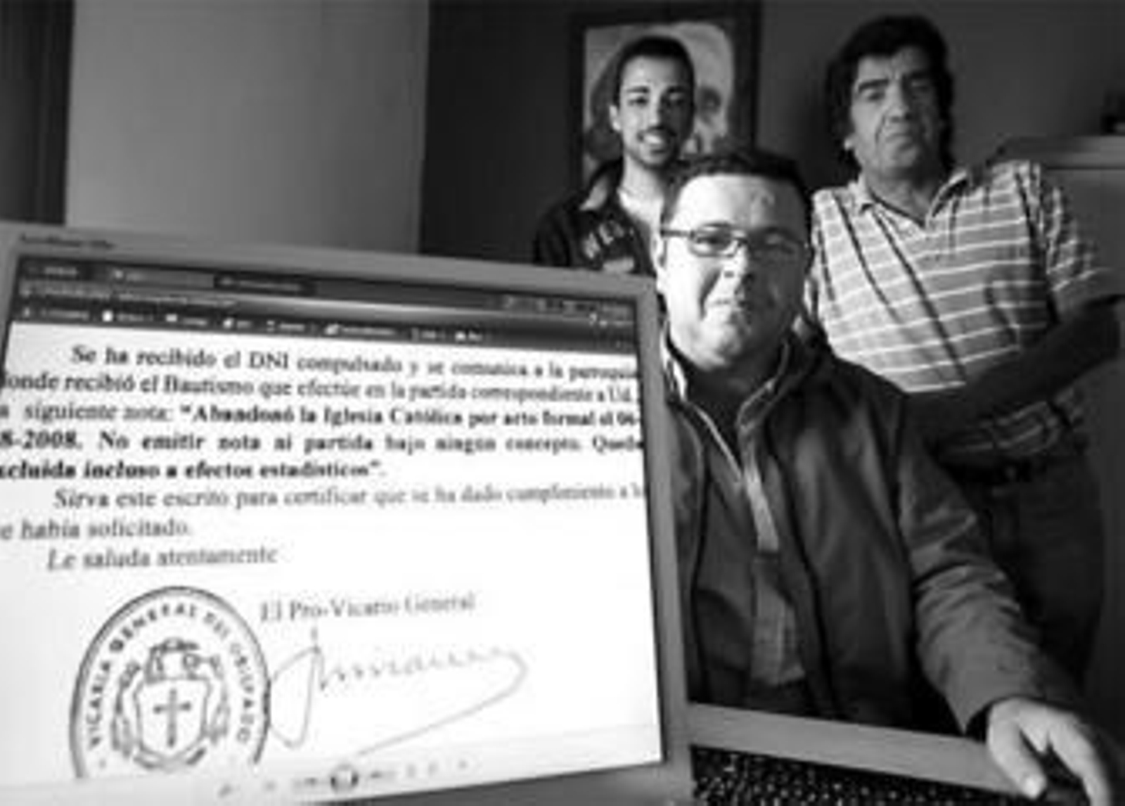 Rafael Hoyo hijo y padre -detrás- y Francisco Moreno junto al documento que confirma su apostasía.