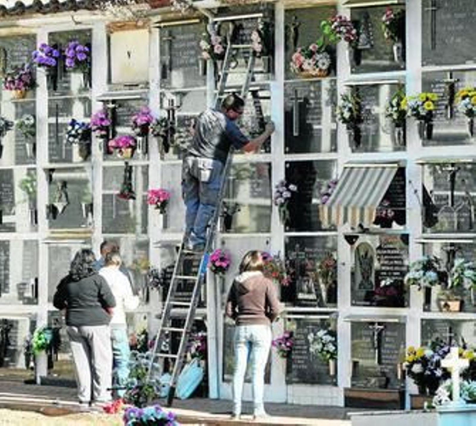 Varias personas limpian los nichos de sus familiares, ayer en el cementerio de San Rafael.