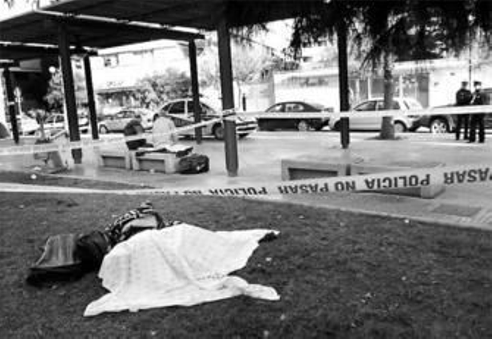 El cuerpo yace en el parque donde dormía, ayer, antes de que el juez ordenara su levantamiento. El cuerpo yace en el parque donde dormía, ayer, antes de que el juez ordenara su levantamiento.